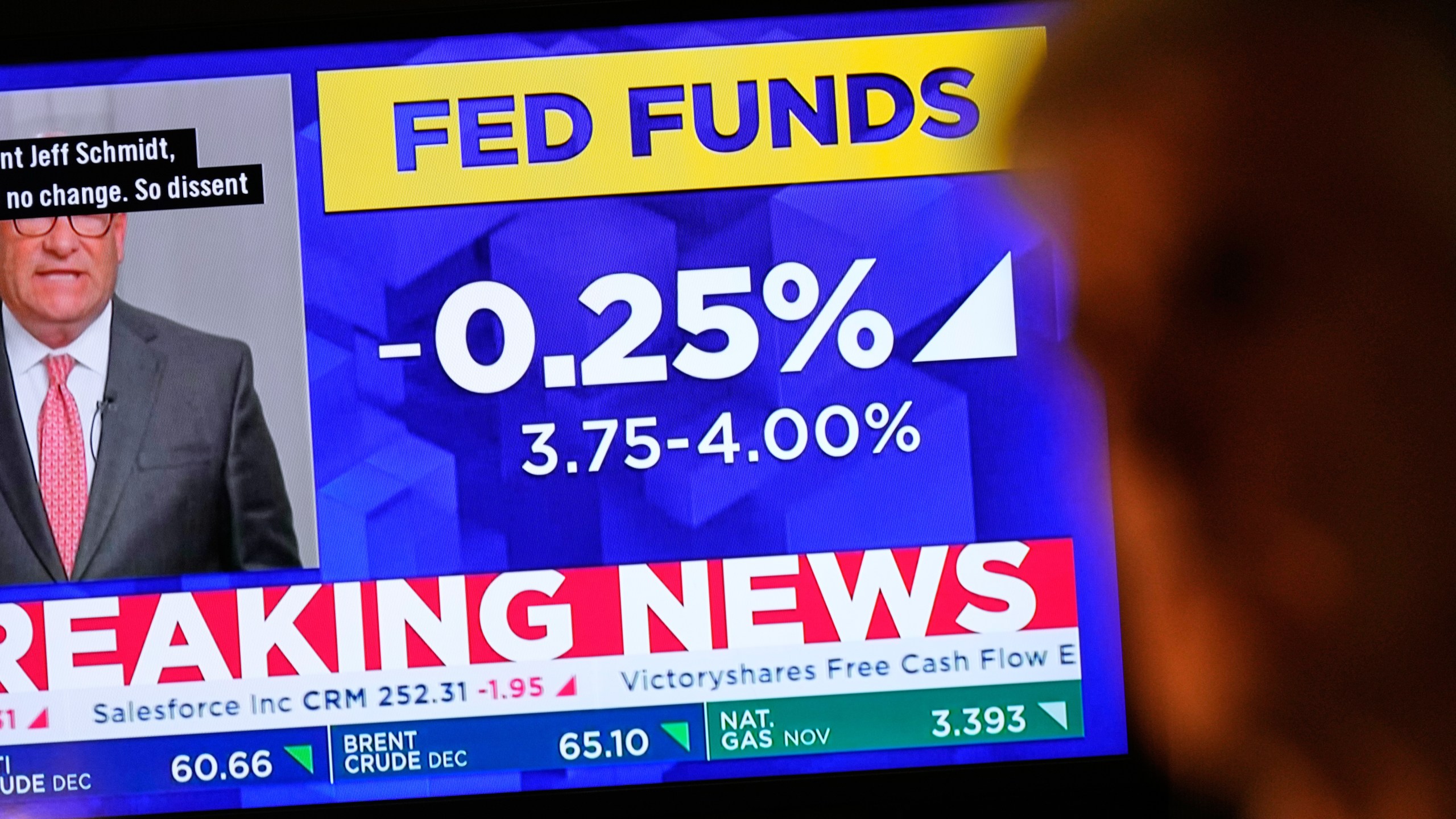 A TV displays news about the Federal Reserve as traders work on the floor at the New York Stock Exchange in New York, Wednesday, Oct. 29, 2025. (AP Photo/Seth Wenig)