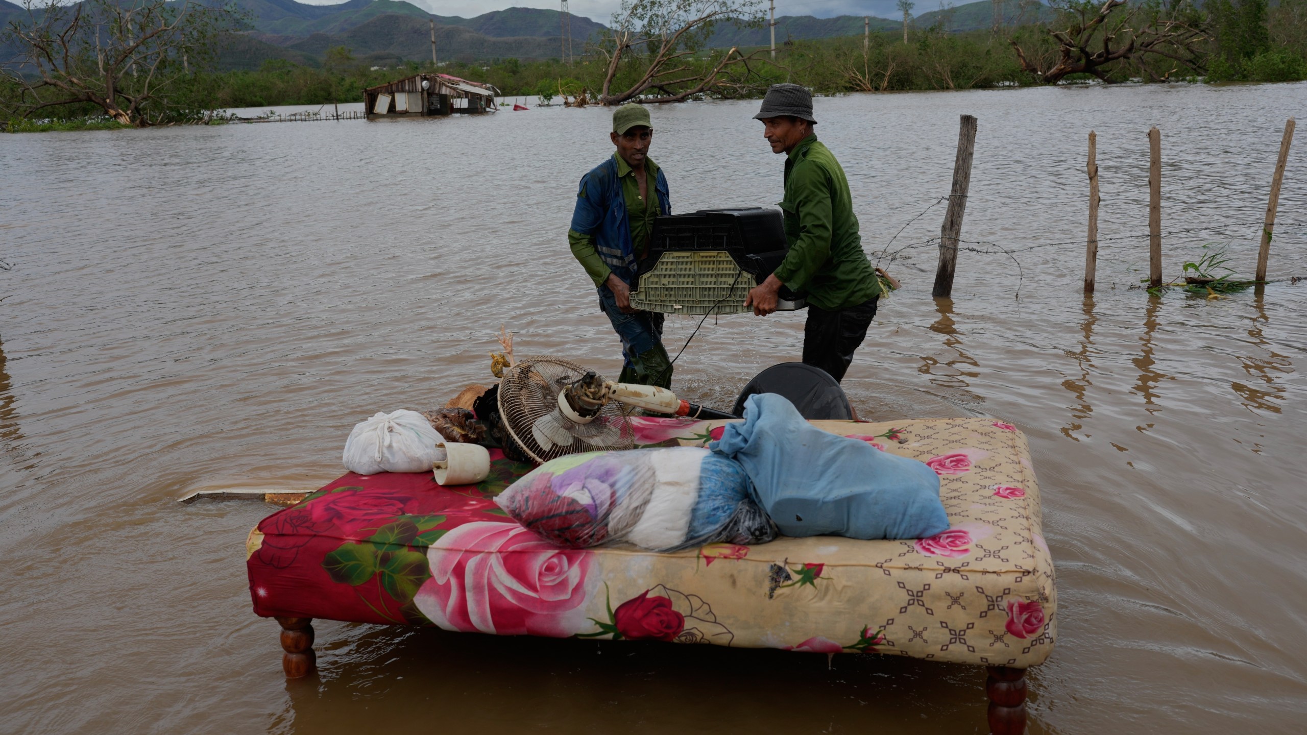 People recover belongings from a home flooded by Hurricane Melissa in Santiago de Cuba, Wednesday, Oct. 29, 2025. (AP Photo/Ramón Espinosa)