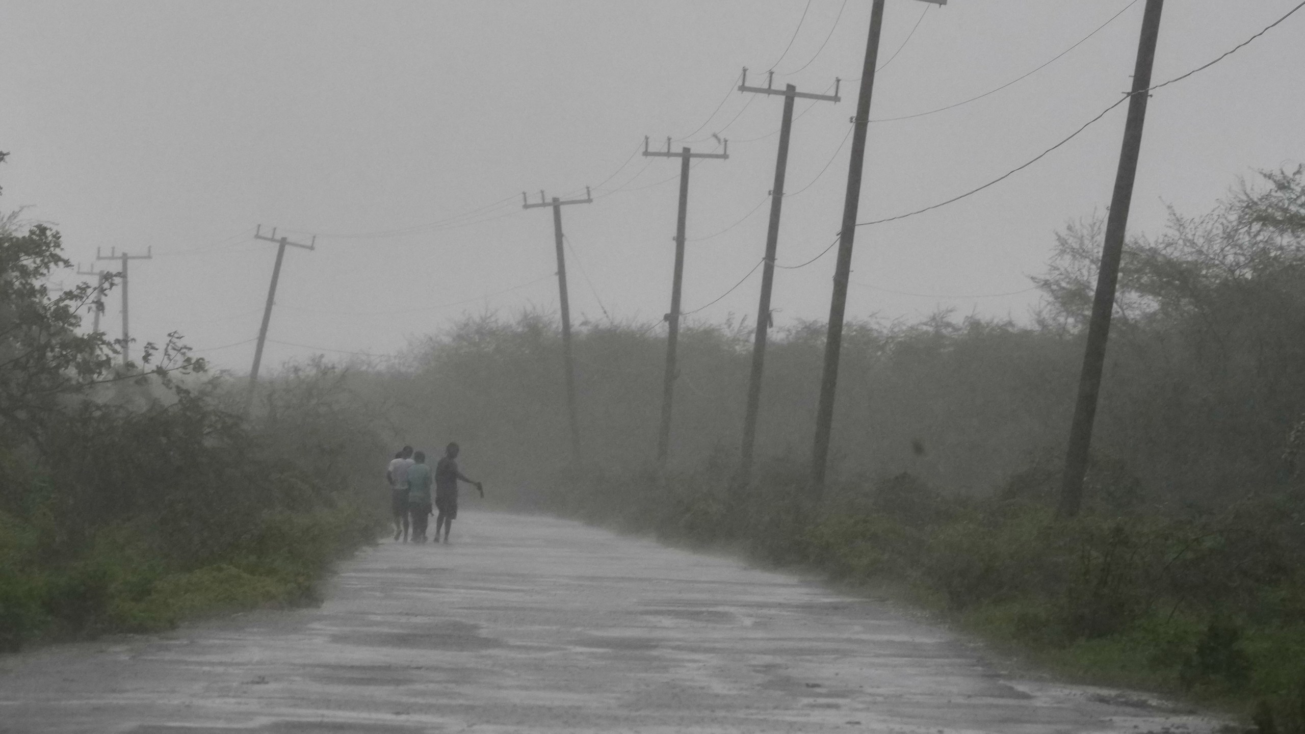 People walk along a road during the passing of Hurricane Melissa in Rocky Point, Jamaica, Tuesday, Oct. 28, 2025. (AP Photo/Matias Delacroix)