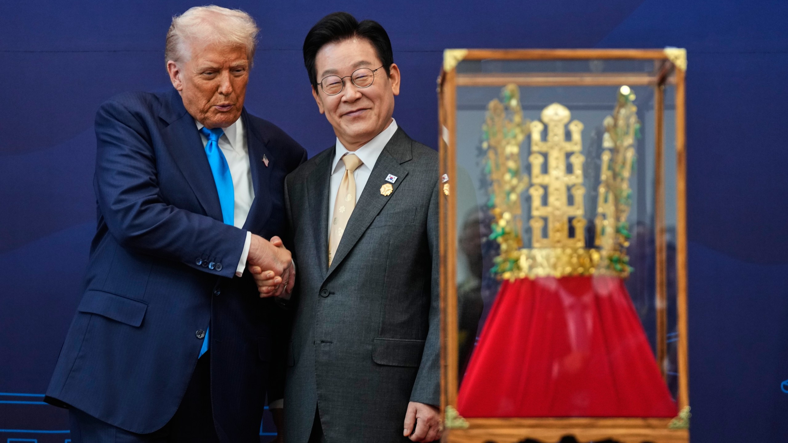 President Donald Trump shakes hands with South Korean President Lee Jae Myung as he receives a gift of a gold crown and an award of the Grand Order of Mugunghwa, not seen, during a high honor ceremony at the Gyeongju National Museum in Gyeongju, South Korea, Wednesday, Oct. 29, 2025. (AP Photo/Mark Schiefelbein)