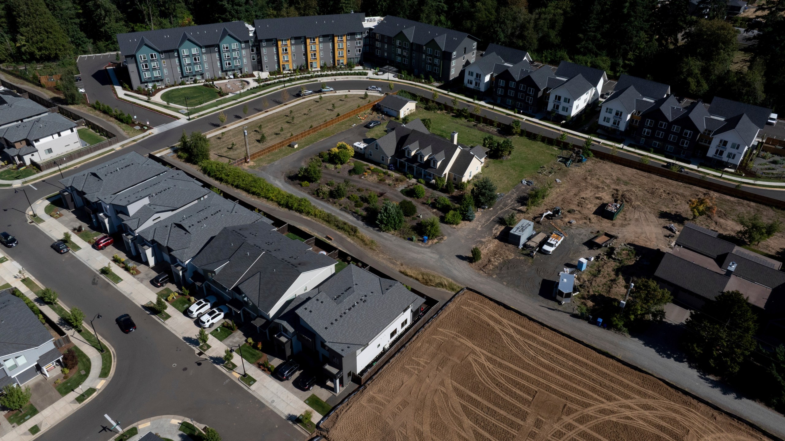 FILE - New construction homes and apartments are seen surrounding an older home on Friday, July 11, 2025, in Happy Valley, Ore. (AP Photo/Jenny Kane, File)