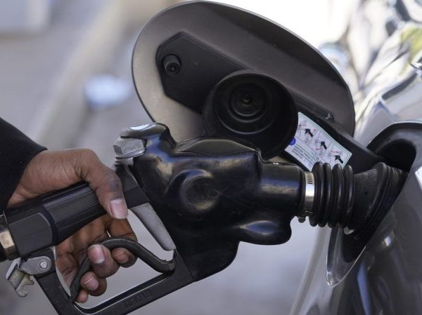 A motorist pumps gasoline into a car