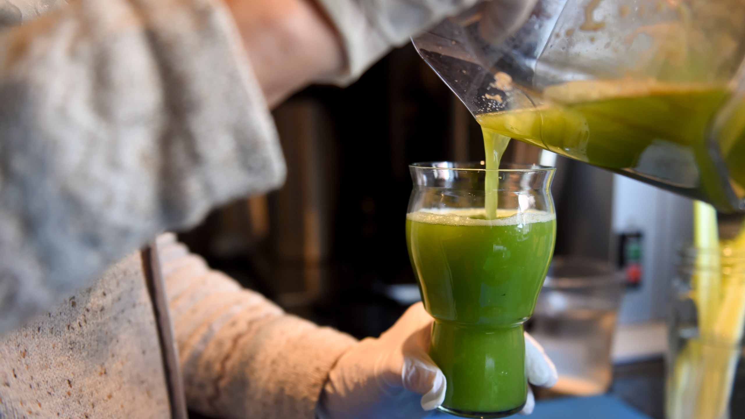 Farmhouse Kitchen owner Martie Samuel pours a glass of celery juice Monday at Farmhouse Kitchen.