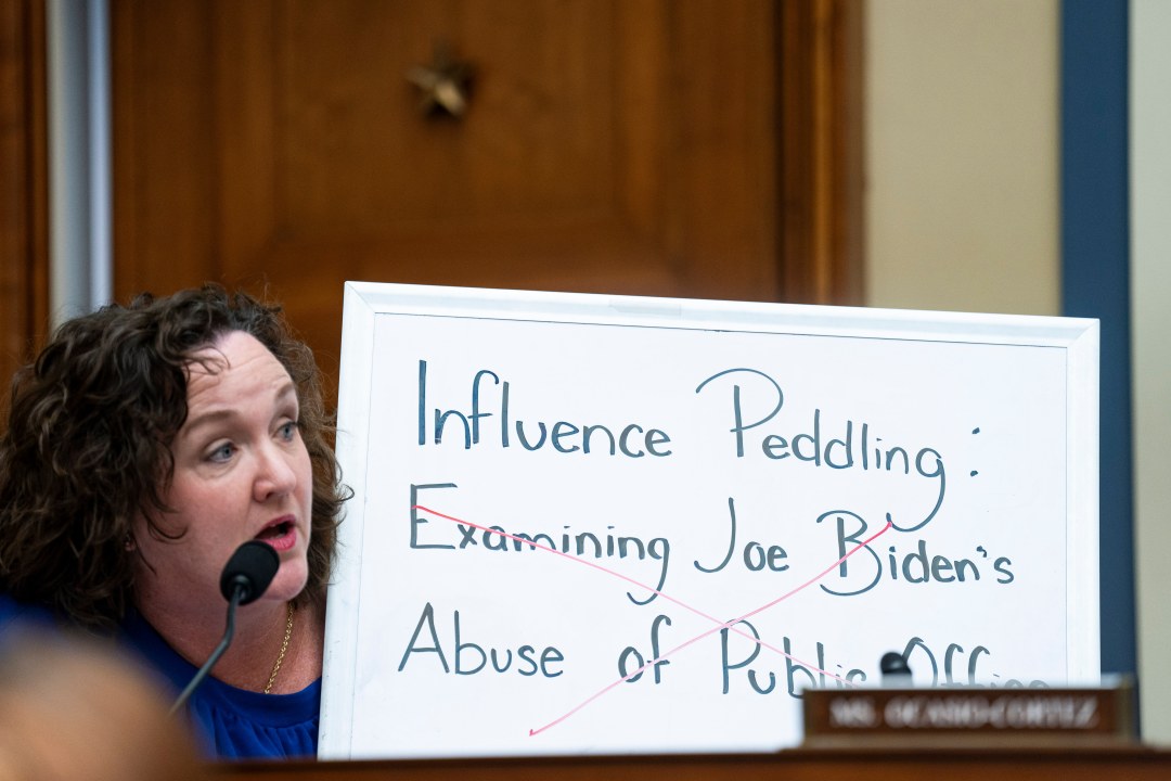 Rep. Katie Porter holds up a white board during a House hearing