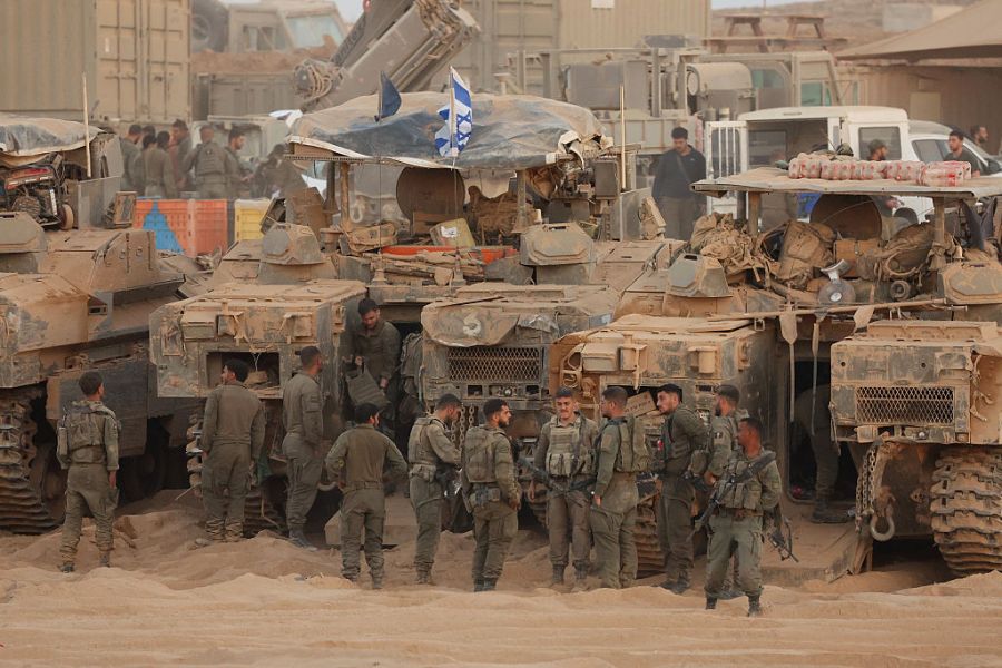 Israeli troops gather at a position along the Israel-Gaza border fence on October 10, 2025. Gaza's civil defence agency said October 10 that Israeli forces have begun pulling back from parts of the territory, particularly in Gaza City and Khan Yunis. Israeli prime minister's office said that the government had "approved the framework" of a hostage release deal with Hamas, as both sides edged closer to ending more than two years of hostilities in Gaza. (Photo by Jack GUEZ / AFP)