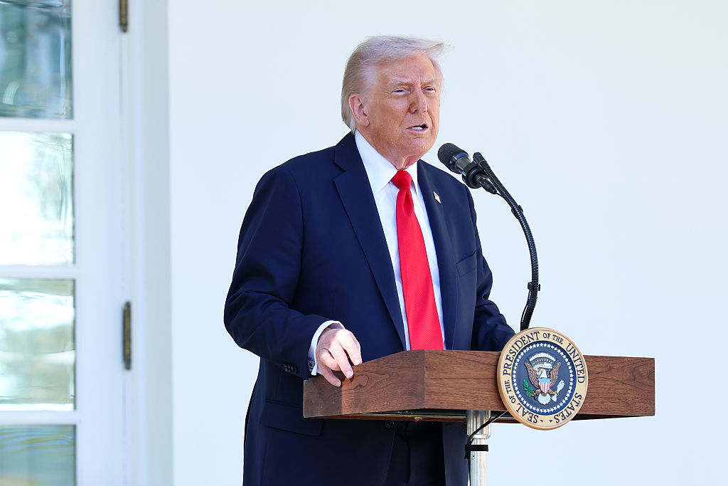 President Donald Trump stands at a podium in front of the White House
