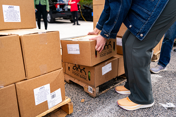 A volunteer picks up a box of food