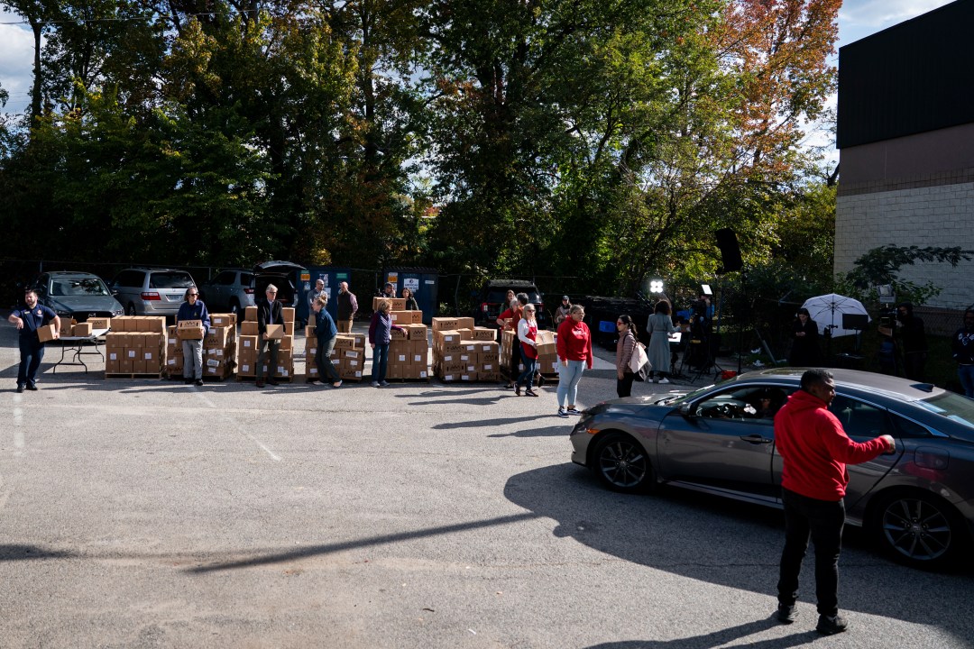 Volunteers hold boxes of food
