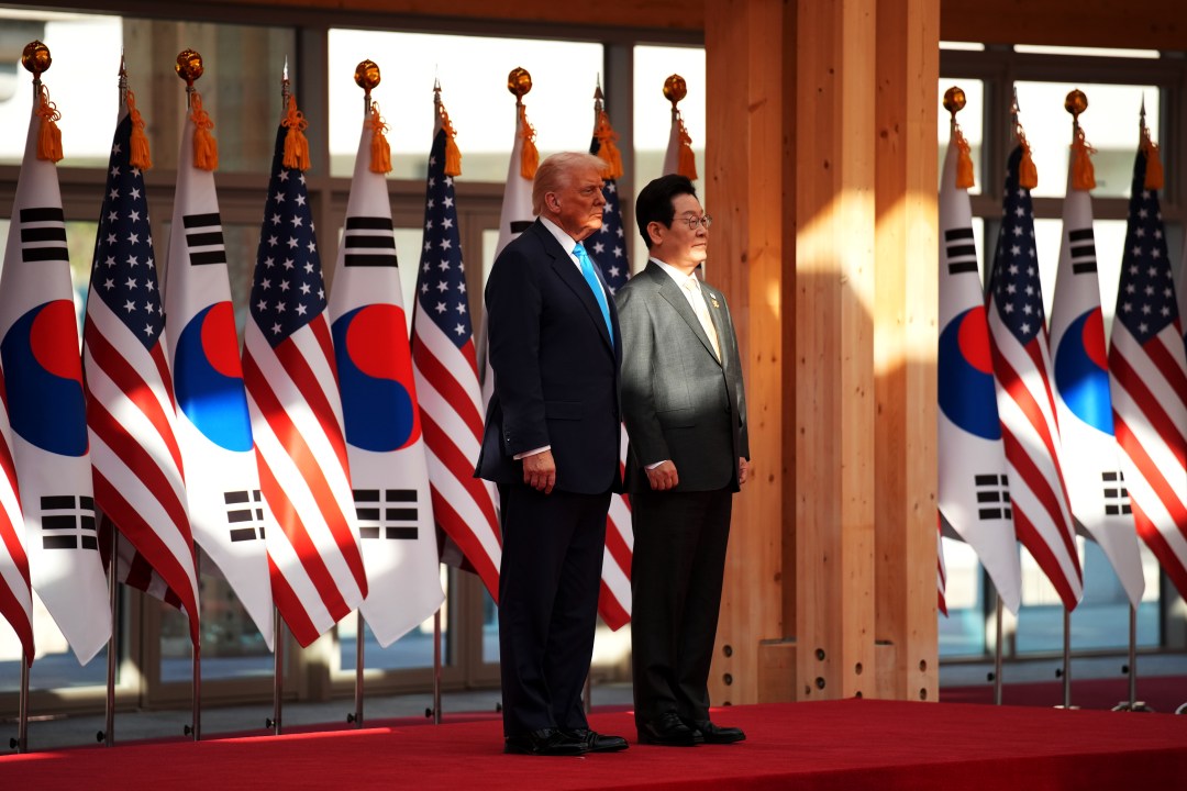 U.S. President Donald Trump and South Korean President Lee Jae Myung stand in front of their respective flags