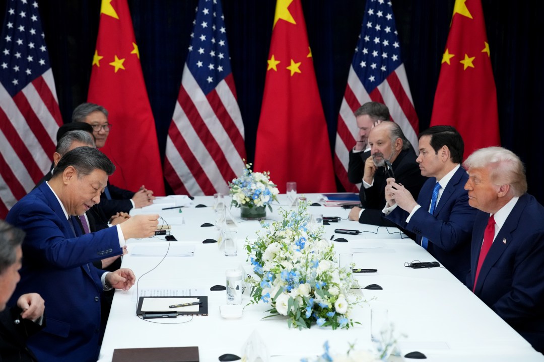 Chinese President Xi Jinping adjusts his earphones during a meeting