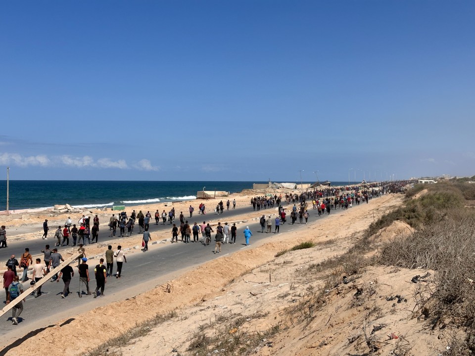 scores of people walk down a road