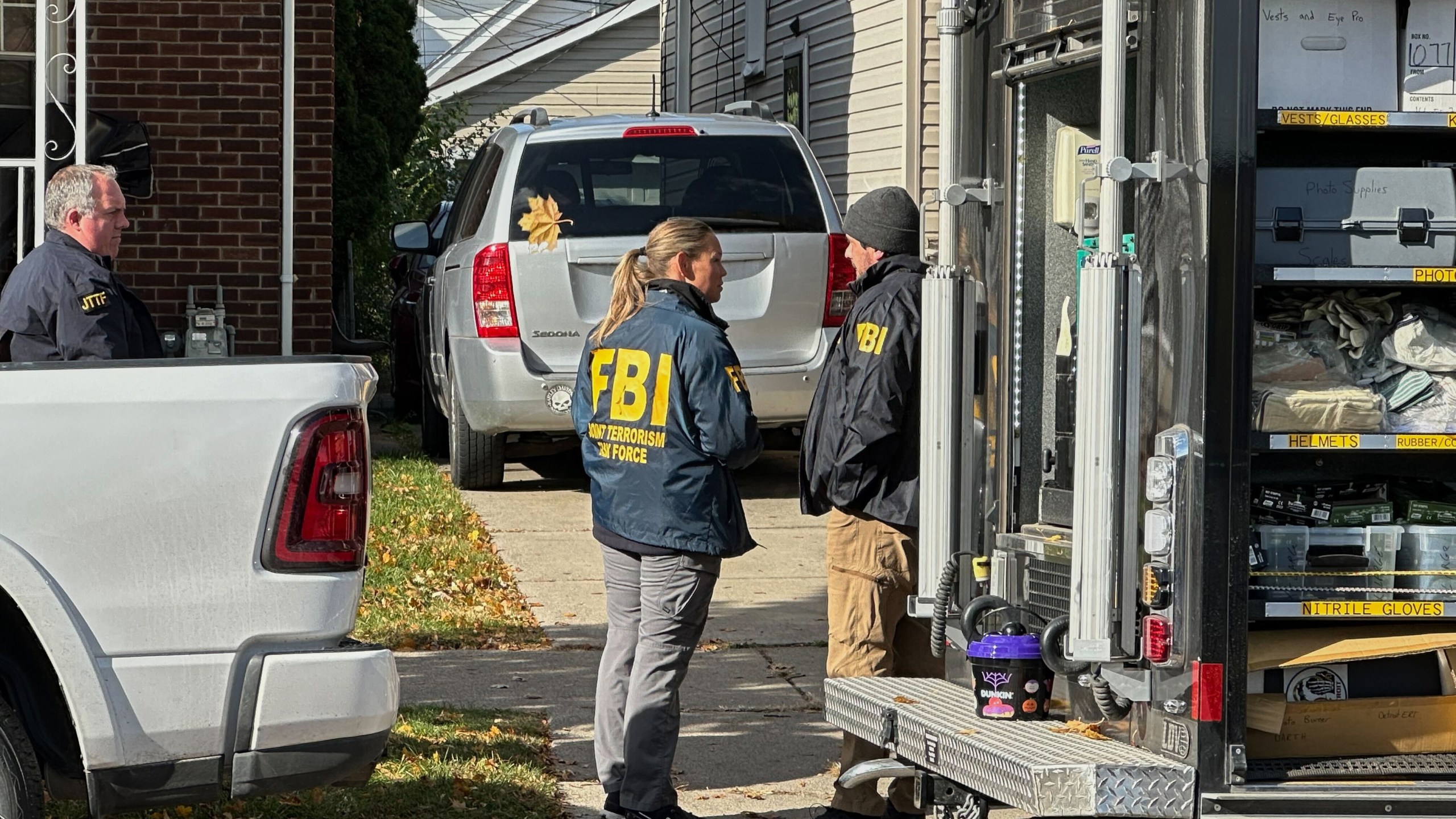 FBI agents gather outside a home in a Dearborn, Mich., neighborhood on Friday, Oct. 31, 2025. (AP Photo/Mike Householder)