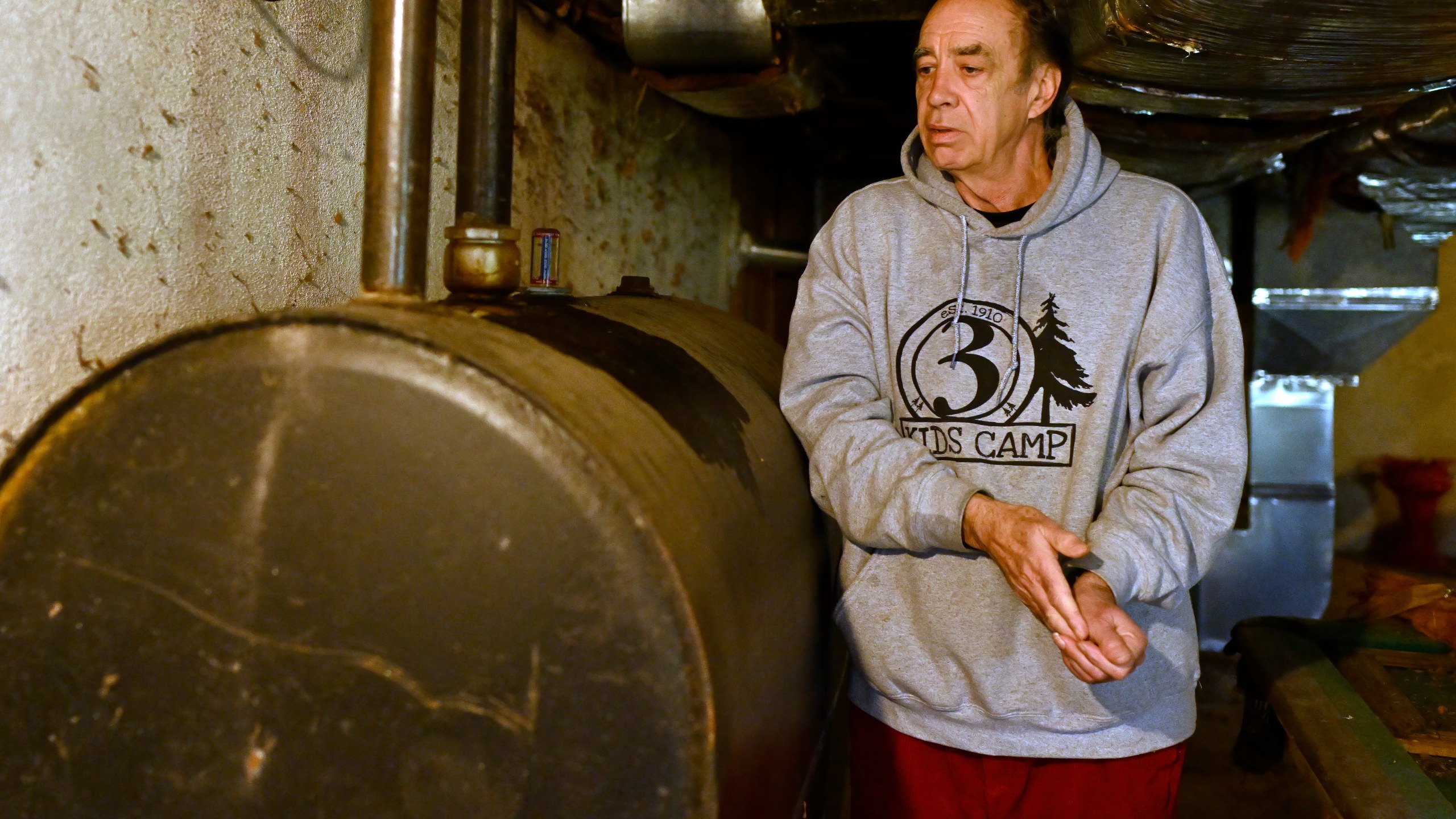 Mark Bain, who is part of the Low Income Home Energy Assistance Program, rubs his hands together as he checks the level on his oil at home in hopes that he will have enough oil to outlast the shutdown, in Bloomfield, Conn., Monday, Oct. 27, 2025. (AP Photo/Jessica Hill)