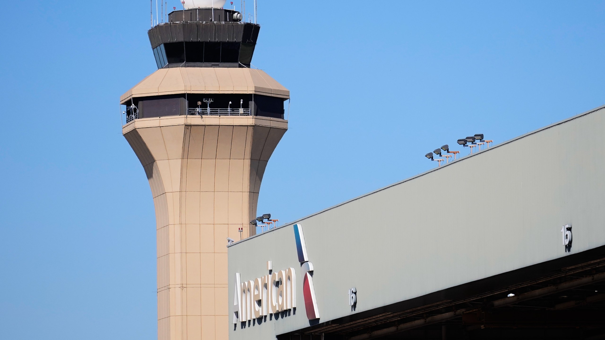 FILE - A control tower by an American Airlines hangar is shown at Dallas Fort Worth International Airport, Oct. 15, 2025, in DFW Airport, Texas. (AP Photo/Tony Gutierrez, file)