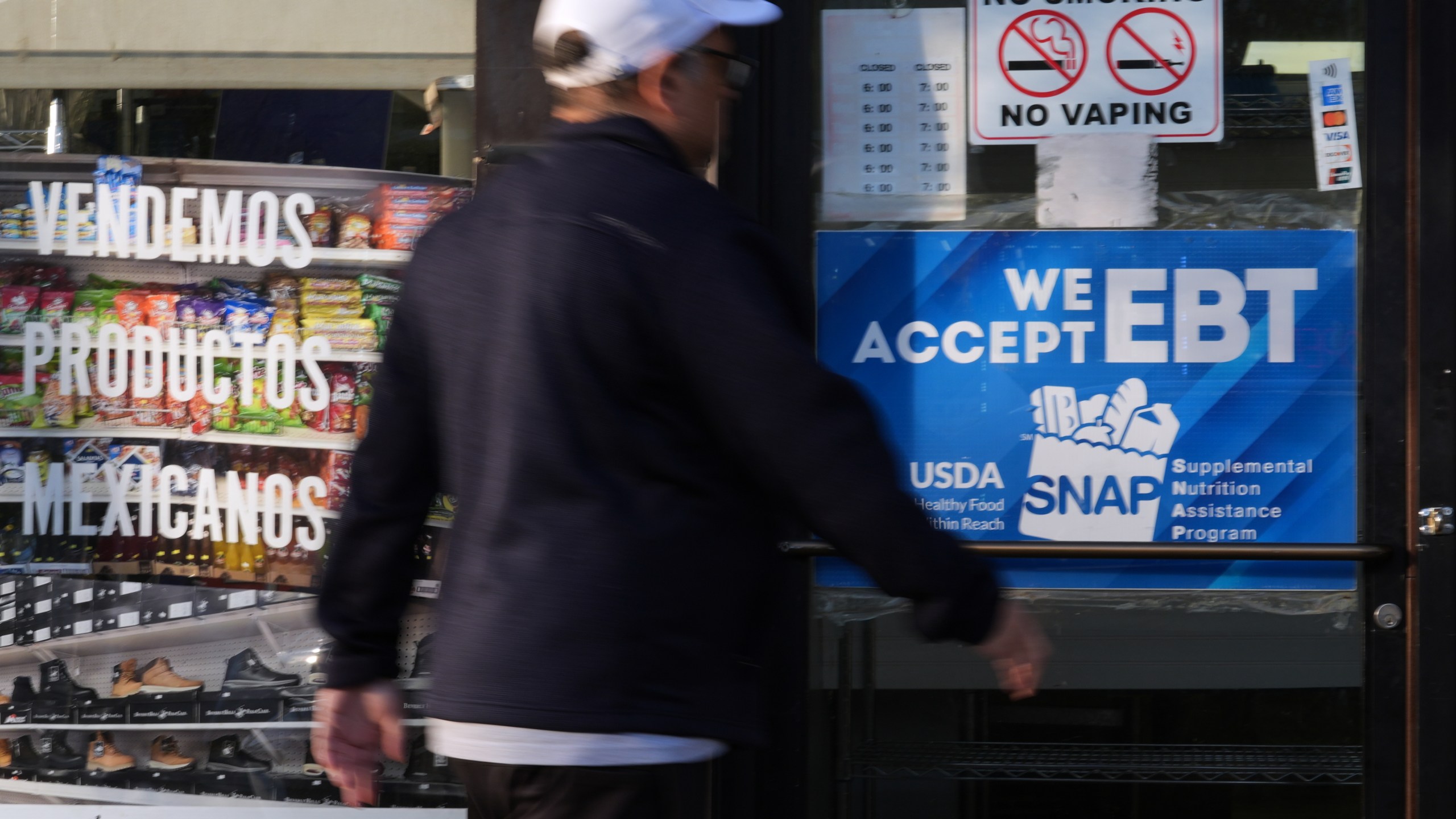 A customer walks into a bakery as a SNAP EBT information sign is displayed at the front door in Chicago, Sunday, Nov. 2, 2025. (AP Photo/Nam Y. Huh)