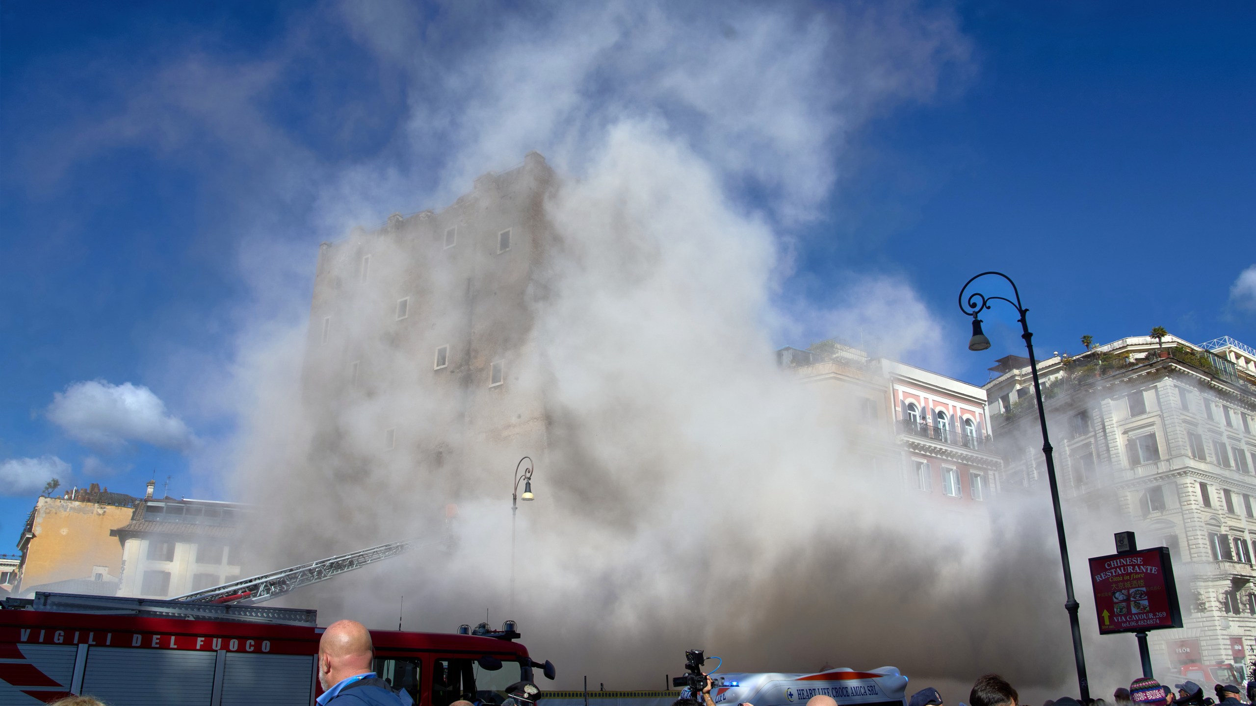 The medieval tower Torre dei Conti near the Roman Forum is engulfed by a cloud of debris from a second collapse after it had partially collapsed during renovation works, in Rome, Italy, Monday, Nov. 3, 2025. (AP Photo/Domenico Stinellis)