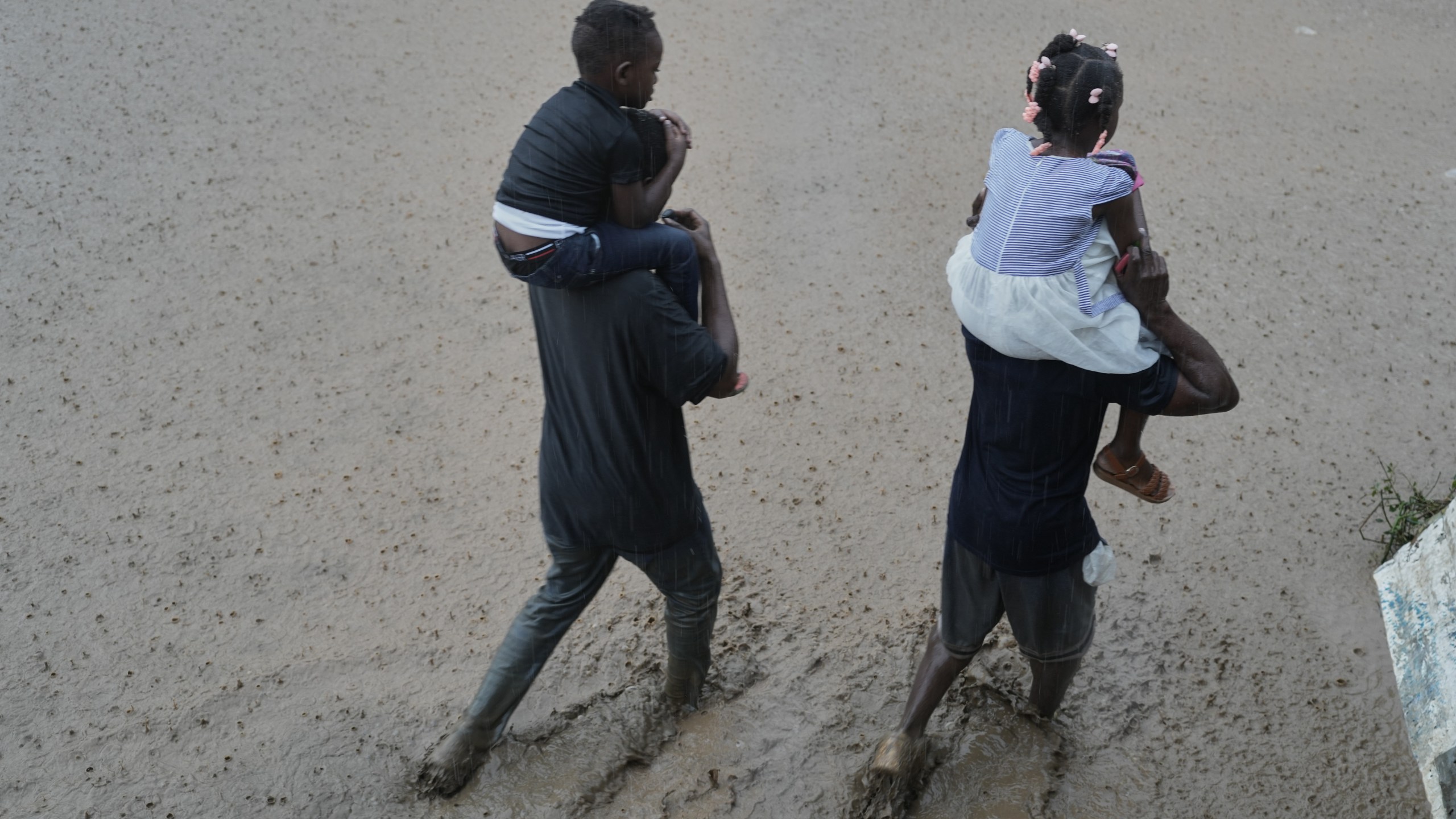 FILE - Residents wade through a flooded street in the aftermath of Hurricane Melissa in Petit-Goave, Haiti, Oct. 30, 2025. (AP Photo/Odelyn Joseph, File)