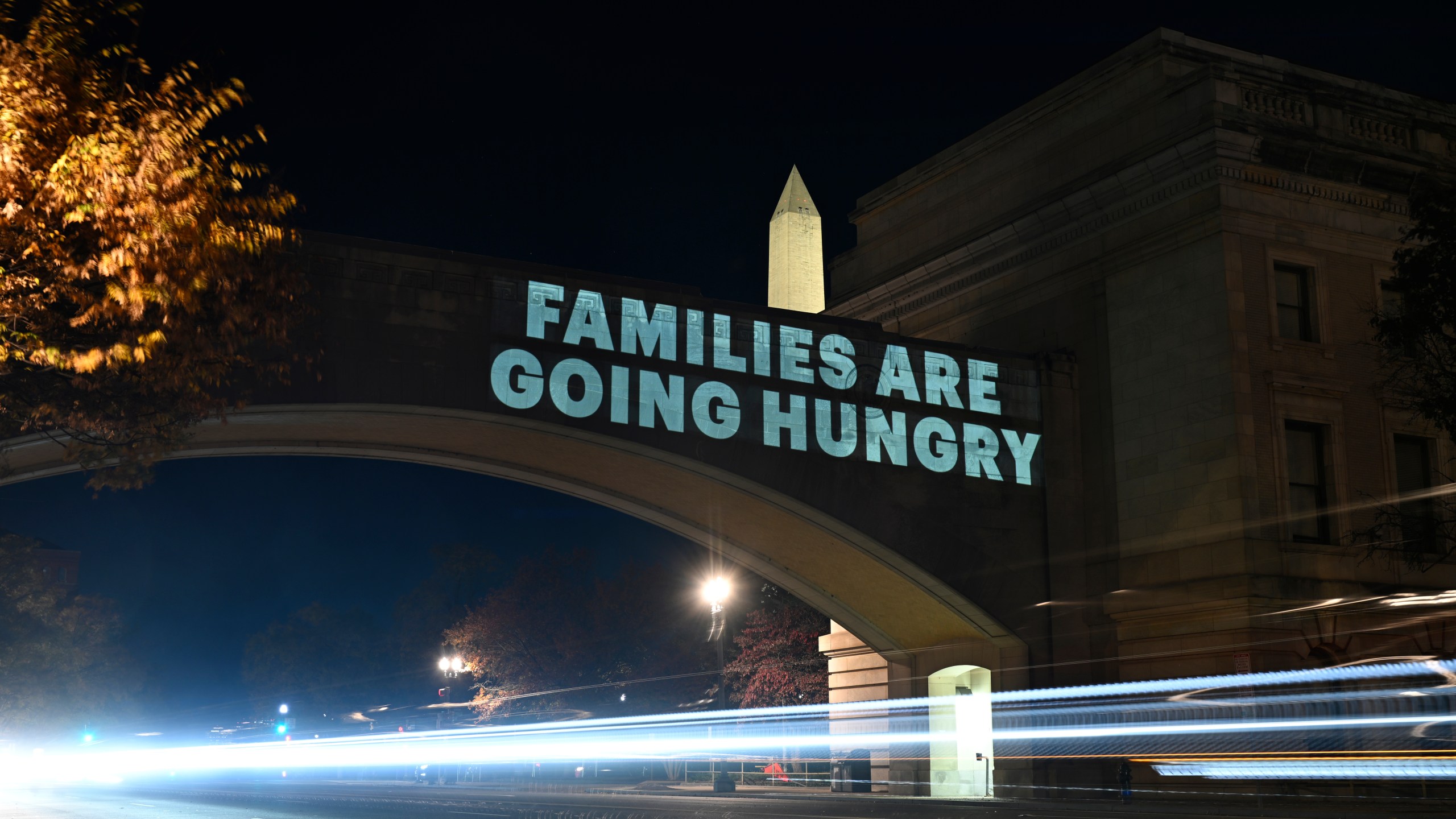 A message from the National Women's Law Center concerning the announcement by the Trump administration of restoring only half funding the SNAP benefits is projected on the U.S. Department of Agriculture building, Monday, Nov. 3, 2025, in Washington. (AP Photo/John McDonnell)