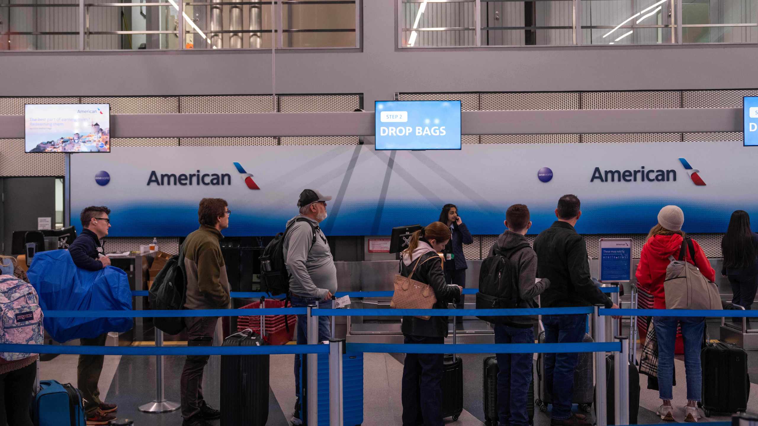 People wait in line to check in to American Airlines flights at Chicago O'Hare International Airport in Chicago, Ill., Sunday, Nov. 9, 2025. (AP Photo/Adam Gray)
