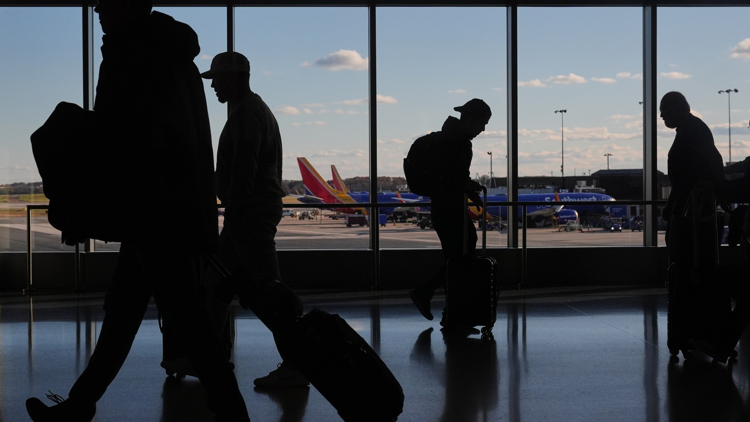 Southwest Airlines planes sit at gates as travelers walk through Baltimore/Washington International Thurgood Marshall Airport in Baltimore, Monday, Nov. 10, 2025. (AP Photo/Stephanie Scarbrough)