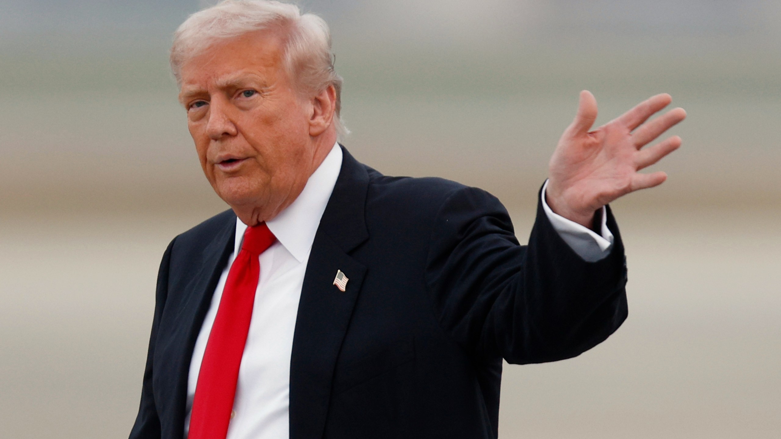 President Donald Trump waves after speaking to the media upon his arrival at Joint Base Andrews, Md., Sunday, Nov. 9, 2025, after returning from his Mar-a-Lago estate in Palm Beach, Fla. and en route to an NFL football game between the Washington Commanders and the Detroit Lions. (AP Photo/Luis M. Alvarez)