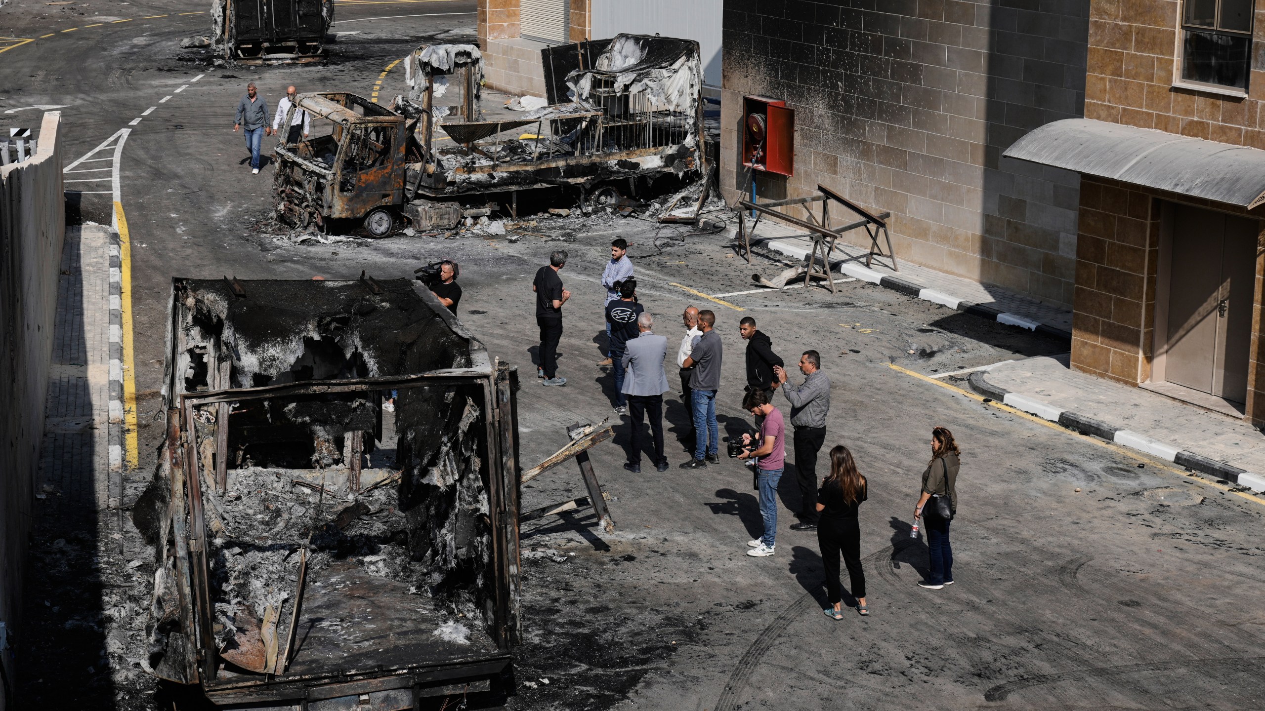 Palestinians and journalists survey damage in an industrial zone following an attack by Israeli settlers the previous day in the West Bank village of Beit Lid, near Tulkarm, Wednesday, Nov. 12, 2025. (AP Photo/Majdi Mohammed)