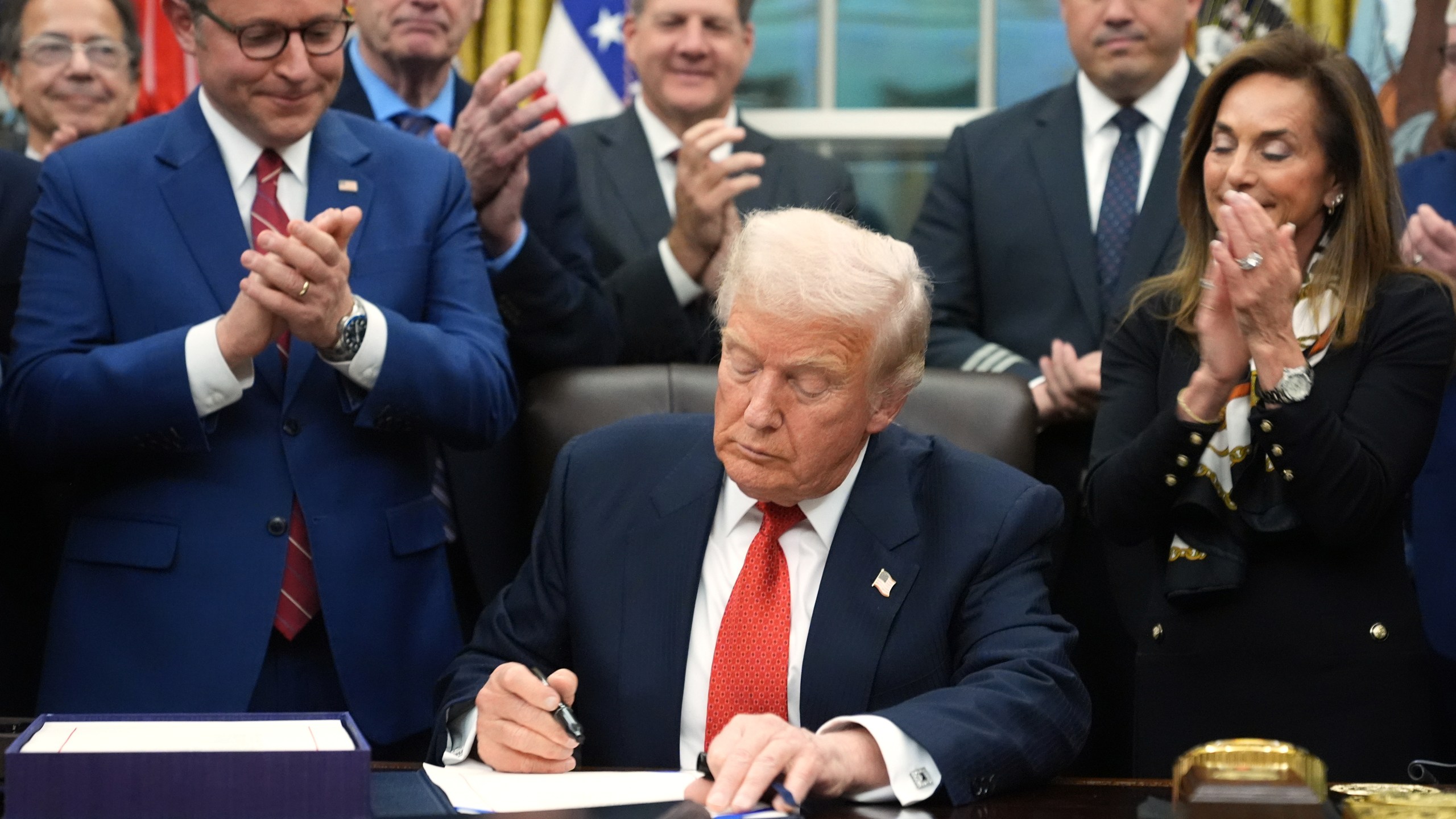 President Donald Trump signs the funding bill to reopen the government, in the Oval Office of the White House, Wednesday, Nov. 12, 2025, in Washington. (AP Photo/Jacquelyn Martin)