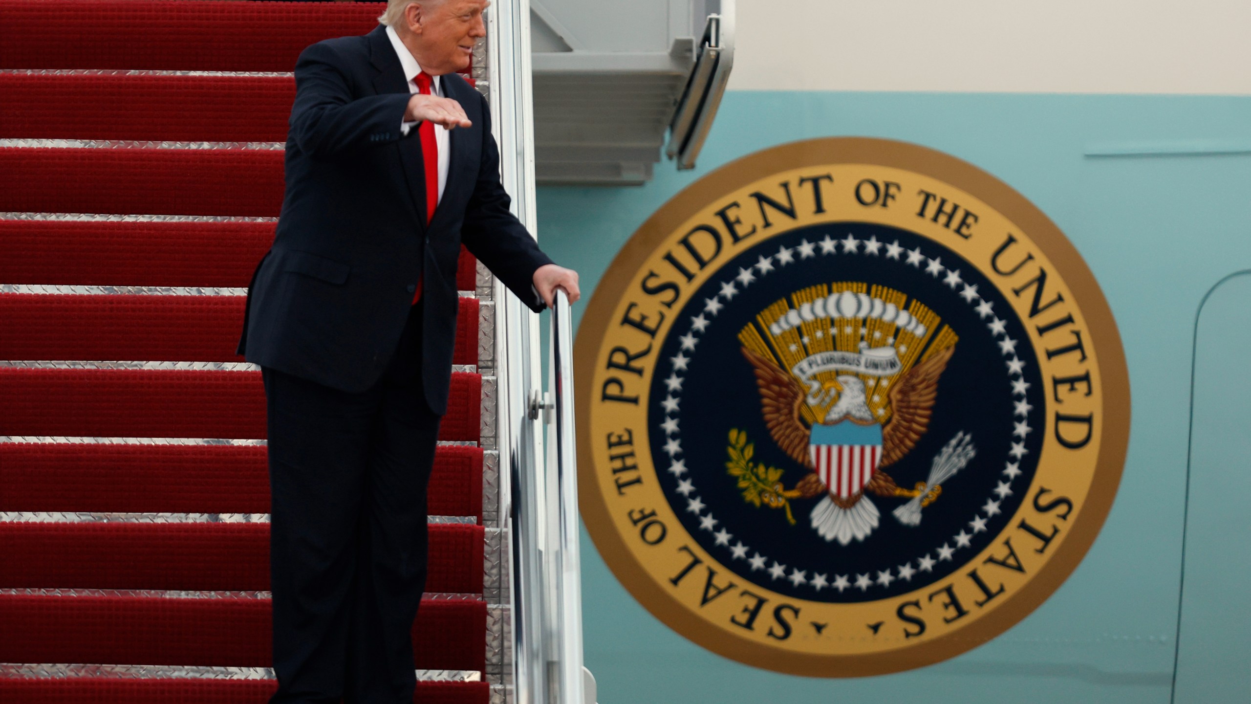 President Donald Trump gestures toward the media as he walks down the stairs of Air Force One upon his arrival at Joint Base Andrews, Md., Sunday, Nov. 9, 2025, after returning from his Mar-a-Lago estate in Palm Beach, Fla. and en route to an NFL football game between the Washington Commanders and the Detroit Lions. (AP Photo/Luis M. Alvarez)
