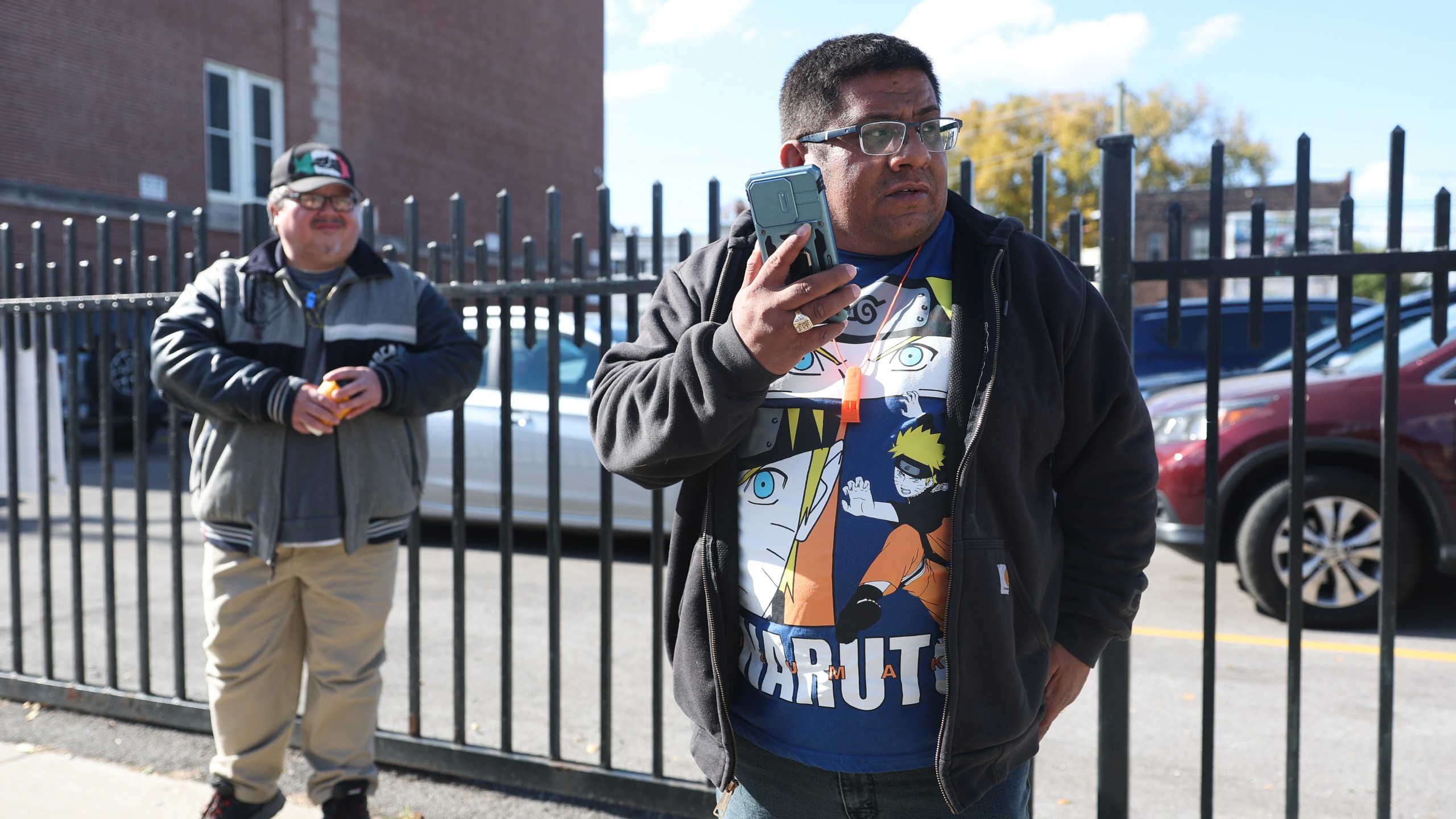 Baltazar Enriquez, president of the Little Village Community Council, speaks on the phone while patrolling for U.S. Immigration and Customs Enforcement (ICE) agents in Chicago's Little Village neighborhood, Wednesday, Oct. 29, 2025. (AP Photo/Talia Sprague)
