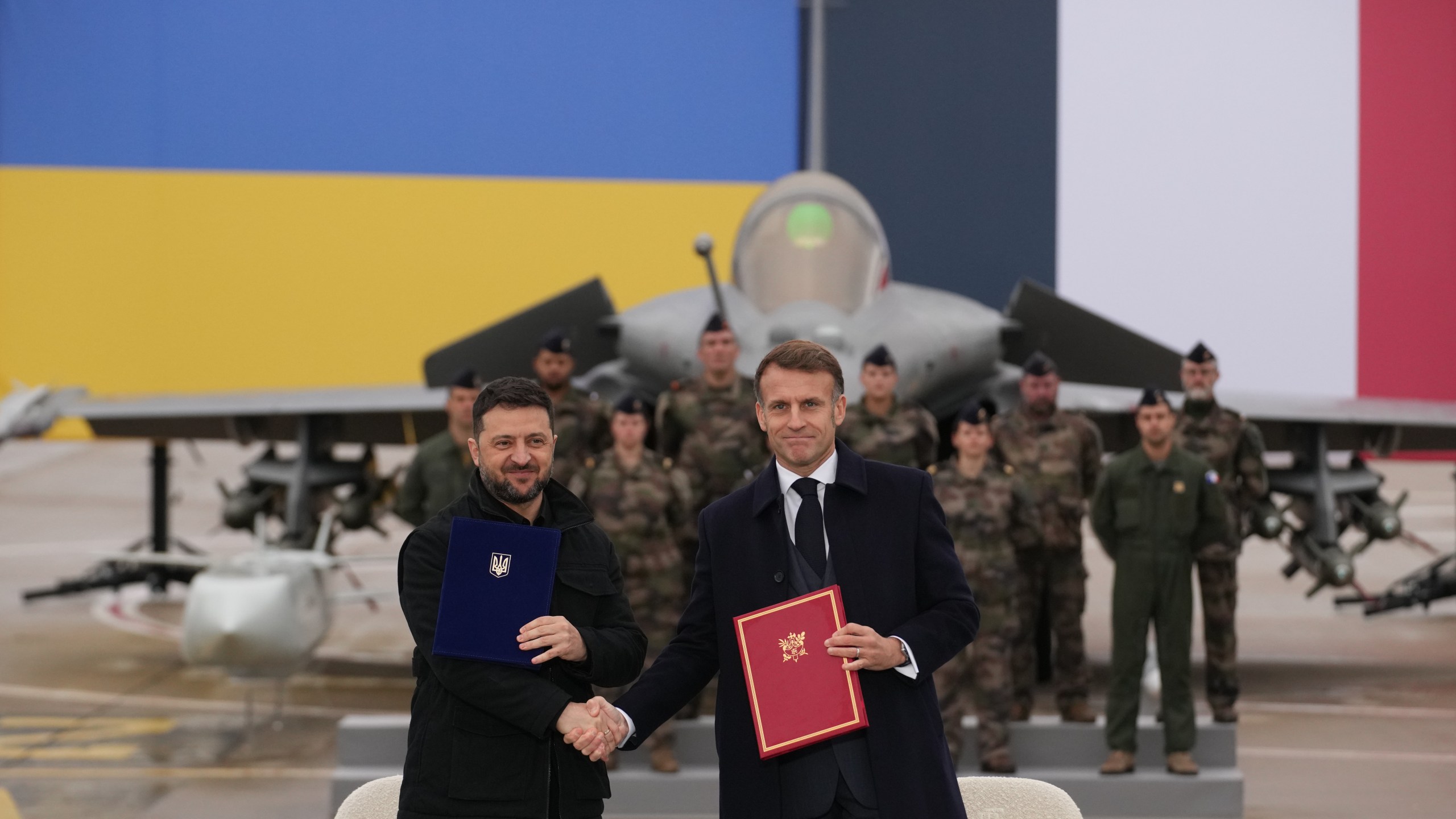 French President Emmanuel Macron, right, and Ukrainian President Volodymyr Zelenskyy shake hands after signing an agreement Monday, Nov. 17, 2025 at the Villacoublay air base near Paris. (AP Photo/Christophe Ena, Pool)