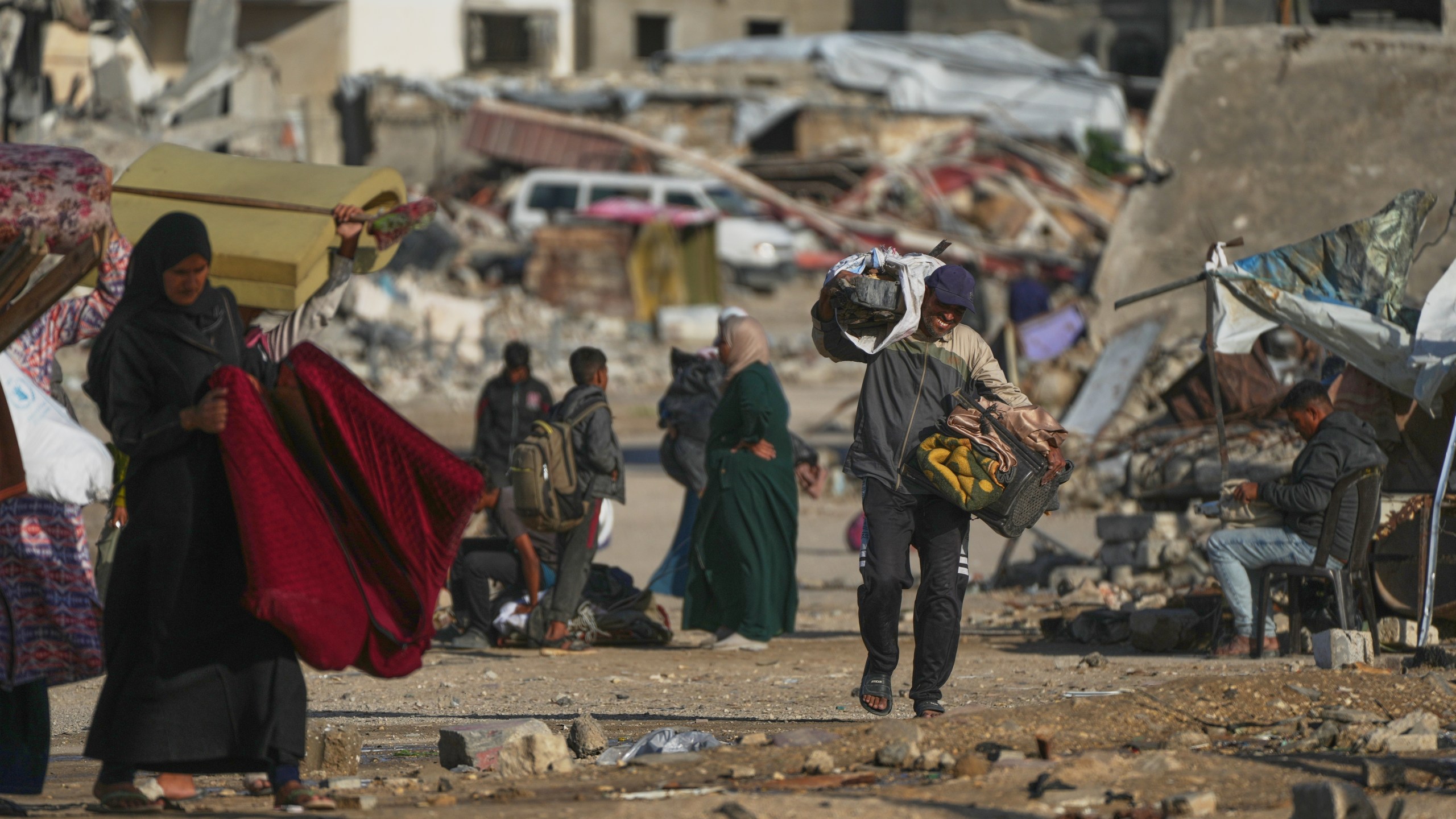 A man Palestinian man carries bags of firewood after collecting them from the rubbish in Khan Younis, southern Gaza Strip, on Saturday, Nov. 15, 2025.(AP Photo/Abdel Kareem Hana)