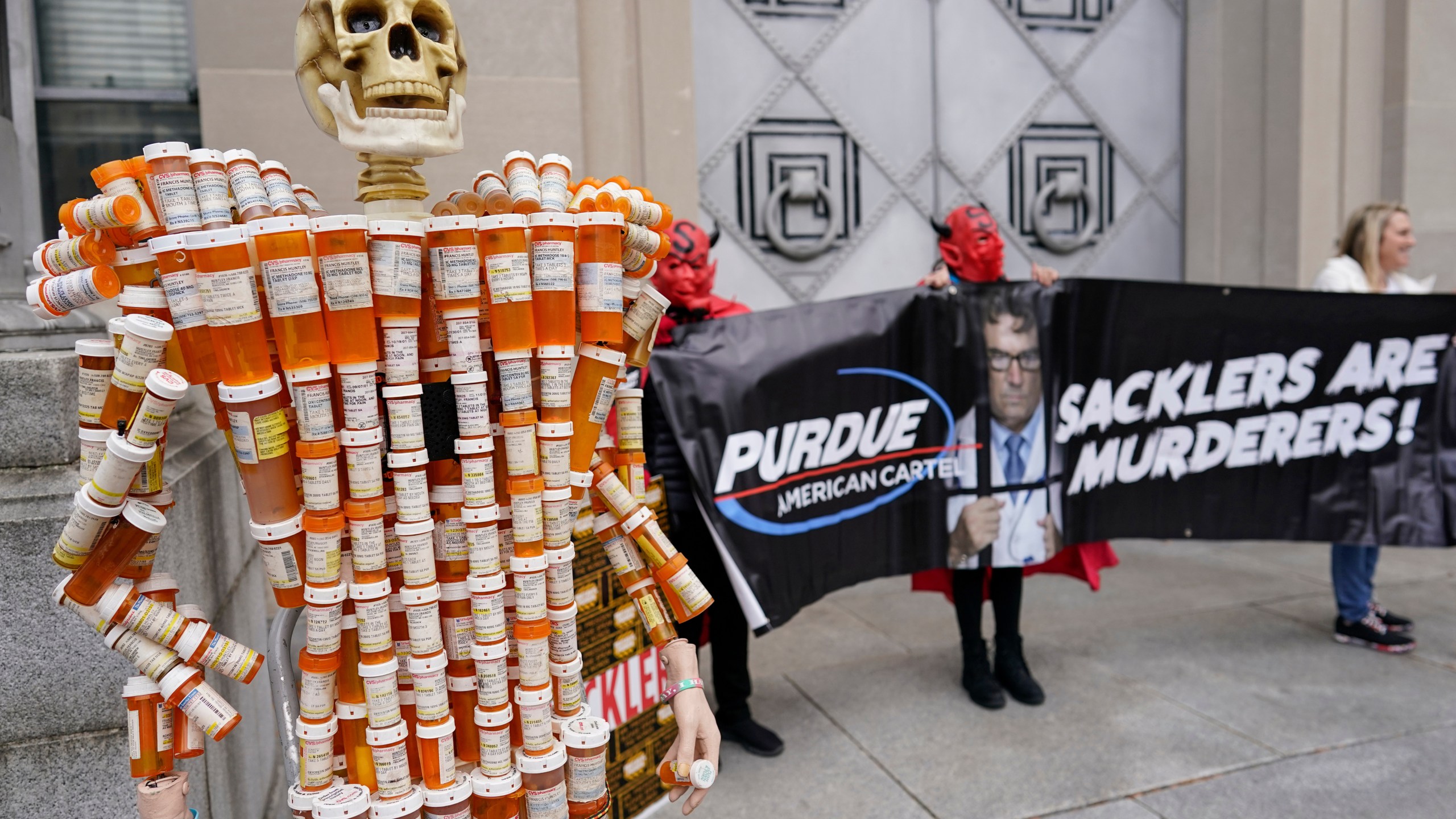 FILE - "Pill Man" made by Frank Huntley of Worcester, Mass., from his opioid prescription pill bottles, is displayed during a protest by advocates for opioid victims outside the Department of Justice, Dec. 3, 2021, in Washington. (AP Photo/Carolyn Kaster, File)