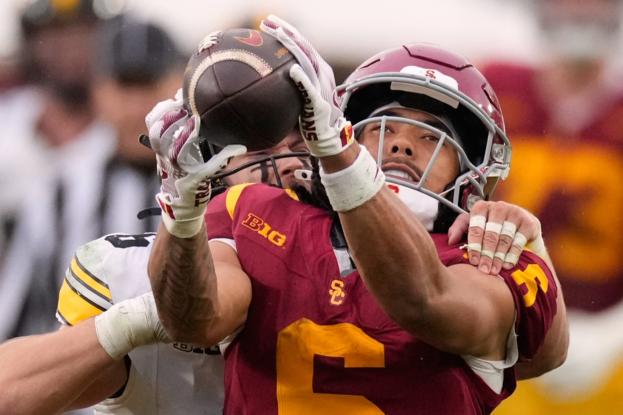 Southern California wide receiver Makai Lemon, right, makes a catch while under pressure from Iowa defensive back Zach Lutmer during the second half of an NCAA college football game, Saturday, Nov. 15, 2025, in Los Angeles. (AP Photo/Mark J. Terrill)