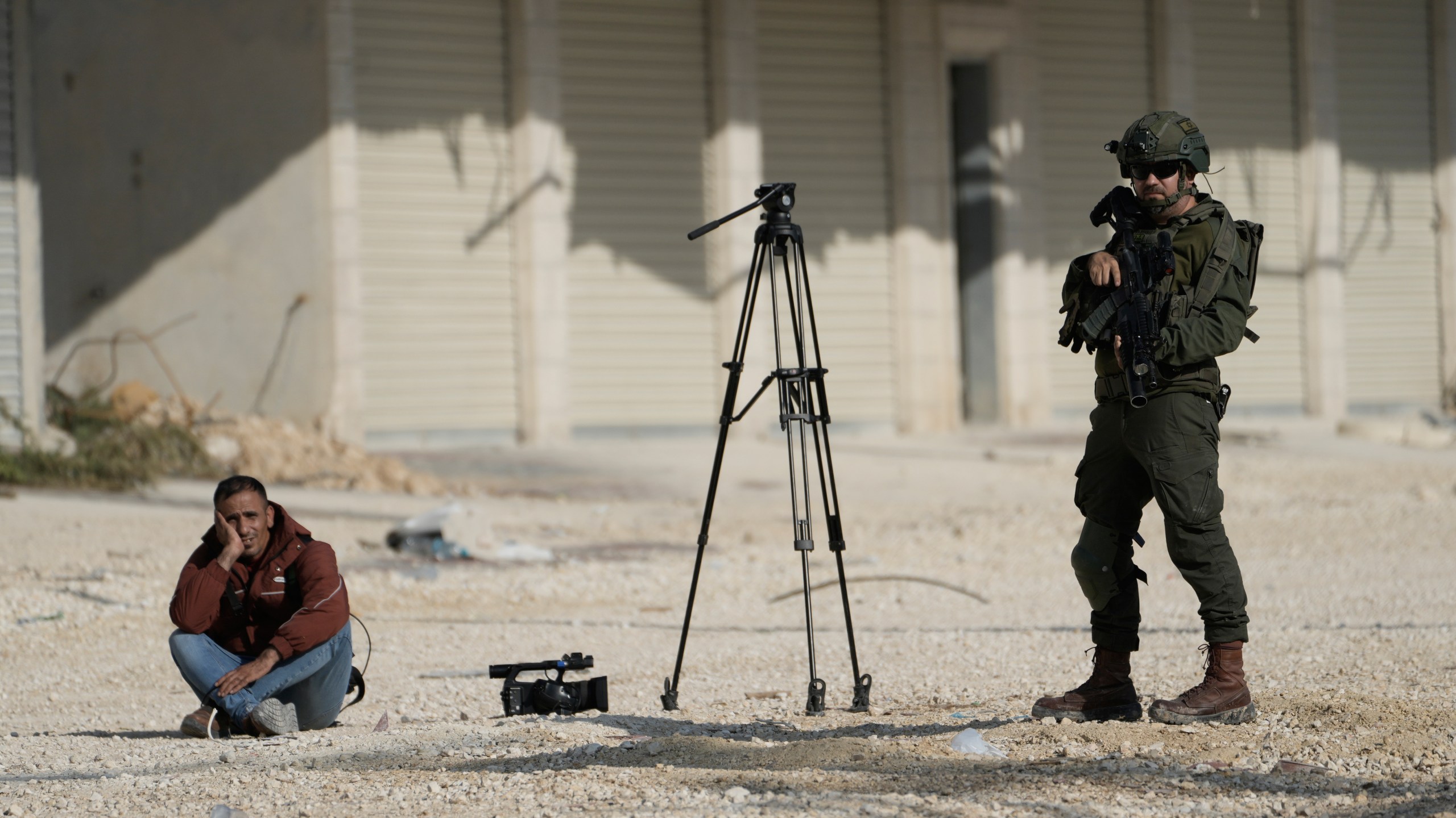 Mahmoud Fawzi, a cameraman for the Jordanian TV channel Roya TV, is detained by Israeli soldiers during a protest by displaced Palestinians calling to return to their houses in the Nur Shams refugee camp, in the West Bank city of Tulkarem, Tuesday, Nov. 18, 2025. (AP Photo/Majdi Mohammed)