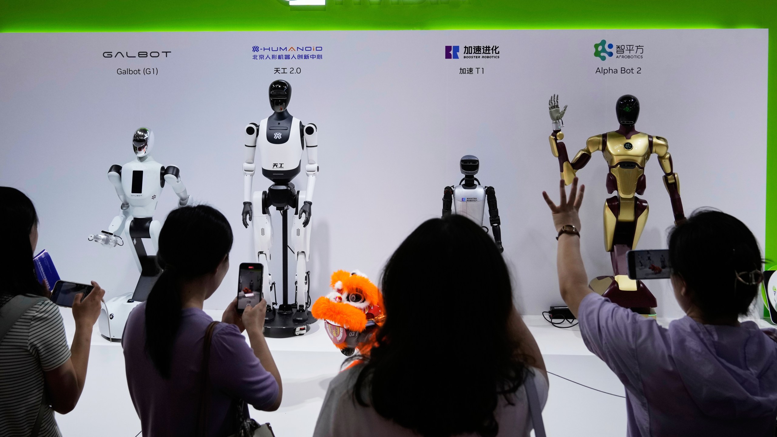 FILE - Visitors give commands to robots at Nvidia's booth during the China International Supply Chain Expo at the China International Exhibition Center in Beijing, China, July 18, 2025. (AP Photo/Mahesh Kumar A., File)
