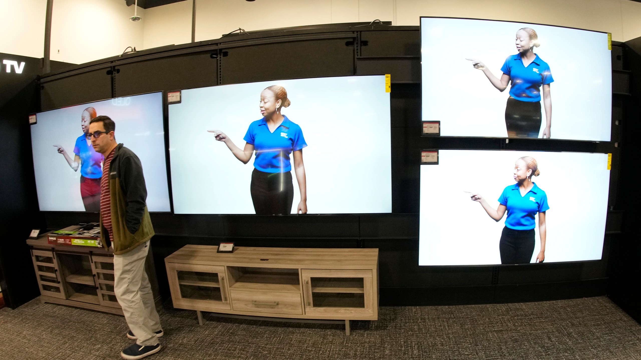 FILE - A customer turns away after looking at big-screen televisions on display in a Best Buy store, Nov. 21, 2023, in southeast Denver. (AP Photo/David Zalubowski, file)