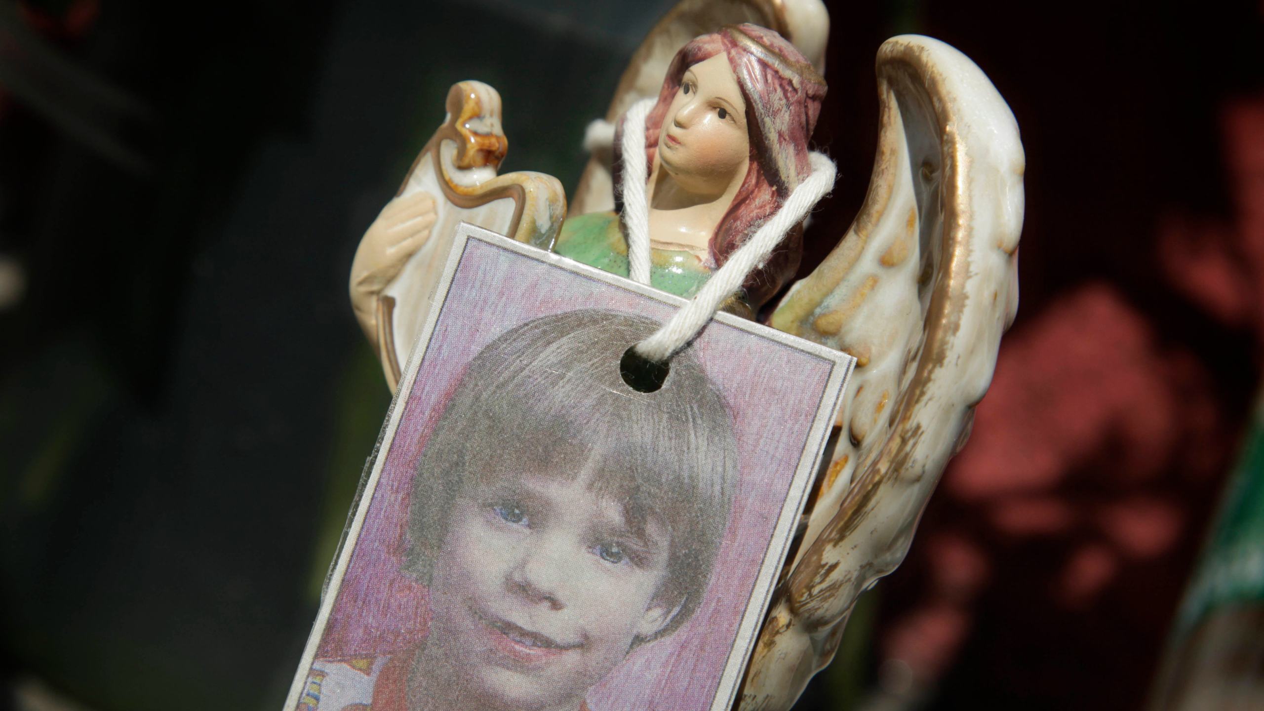 FILE - A photograph of Etan Patz hangs on an angel figurine, as part of a makeshift memorial in the SoHo neighborhood of New York, May 28, 2012. (AP Photo/Mark Lennihan, File)
