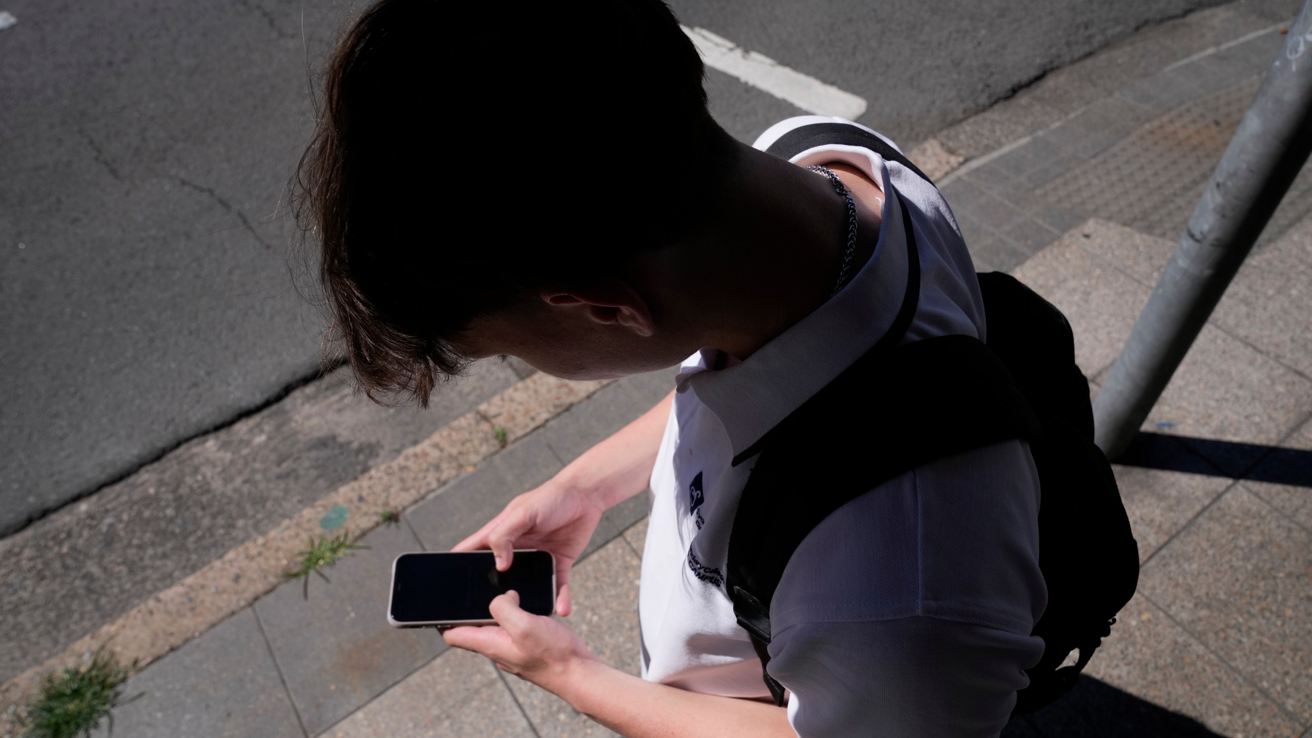 FILE - A teenage boy uses his phone in Sydney, Nov. 8, 2024. (AP Photo/Rick Rycroft, File)