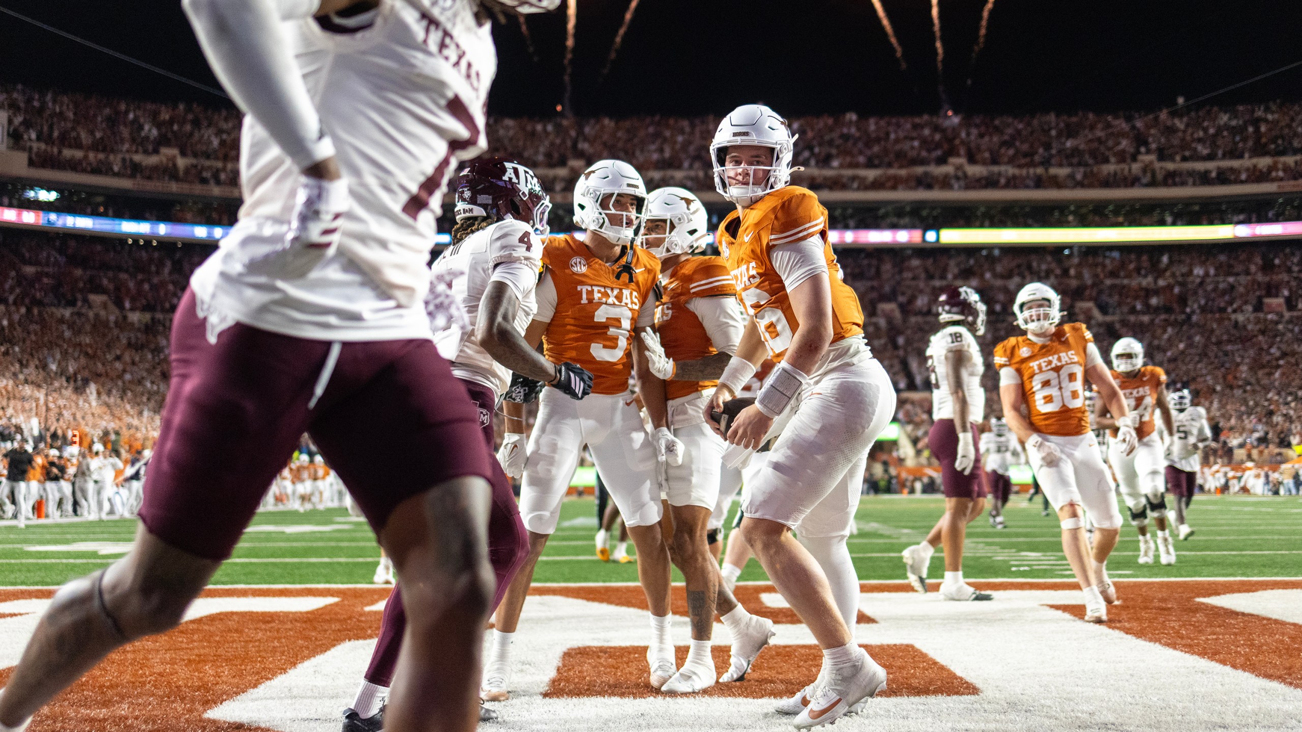 Texas quarterback Arch Manning (16) scores a touchdown past Texas A&M cornerback Will Lee III (4) with wide receiver Emmett Mosley V (3) during the second half of an NCAA college football game Friday, Nov. 28, 2025, in Austin, Texas. (AP Photo/Stephen Spillman)