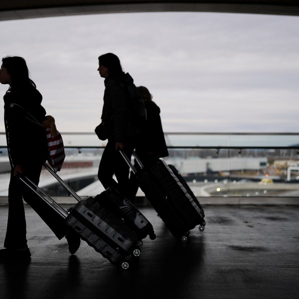 Travelers make their way through the Nashville International Airport, Tuesday, Nov. 25, 2025, in Nashville, Tenn. (AP Photo/George Walker IV)