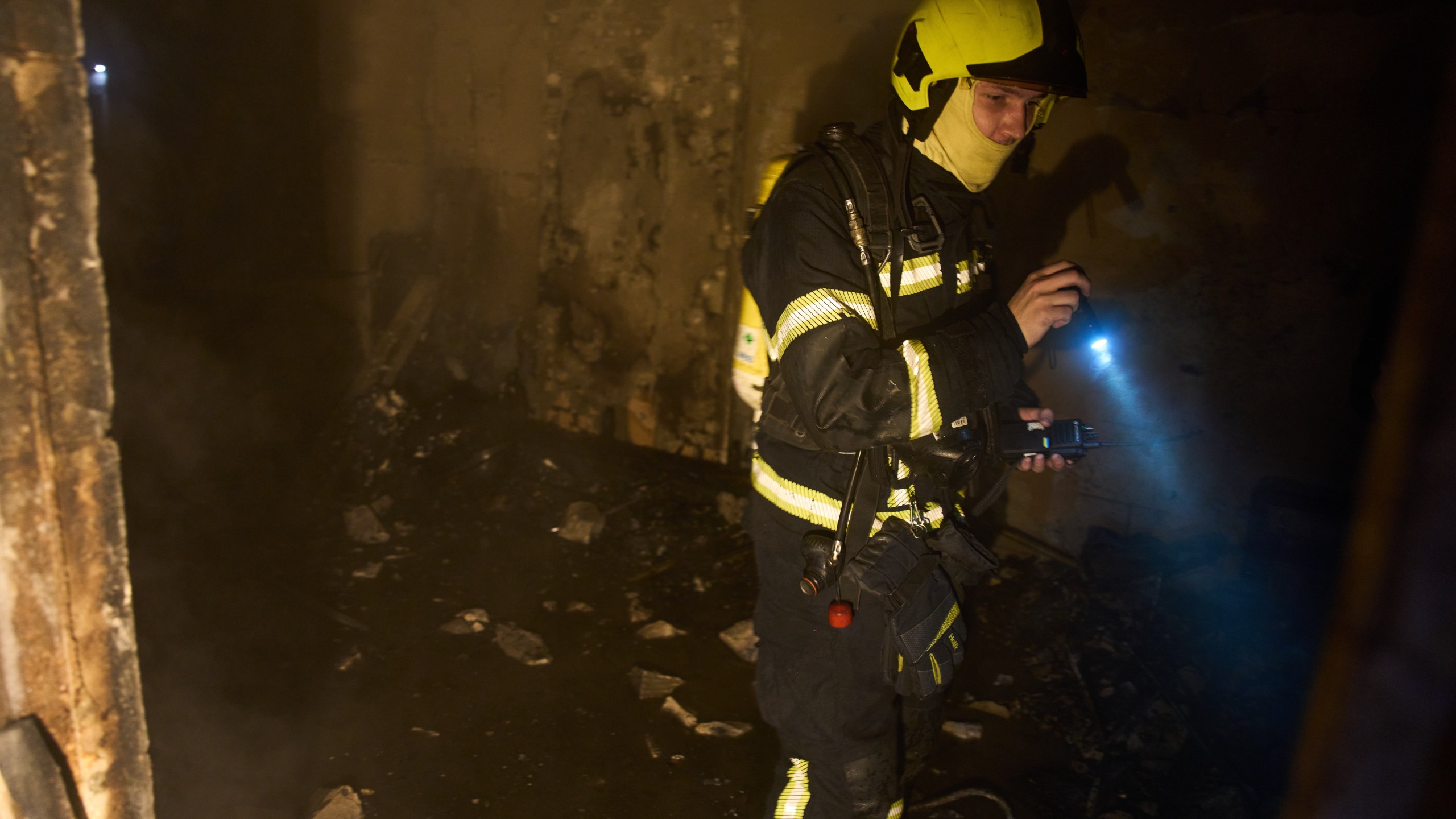 A rescuer searches for victims after a drone hit a residential building during Russia's night missile and drone attack in Kyiv, Ukraine, Saturday, Nov. 29, 2025. (AP Photo/Efrem Lukatsky)