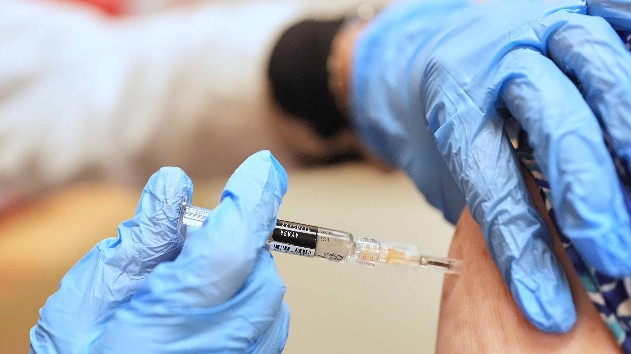 A pharmacist giving a person a vaccine