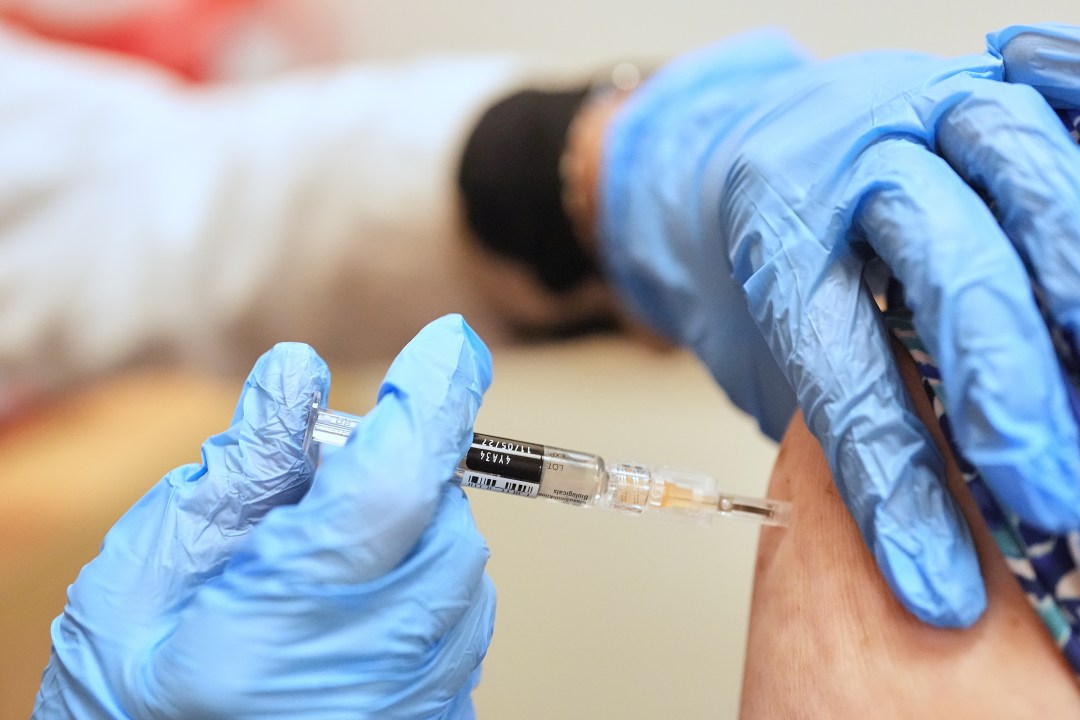 A pharmacist giving a person a vaccine