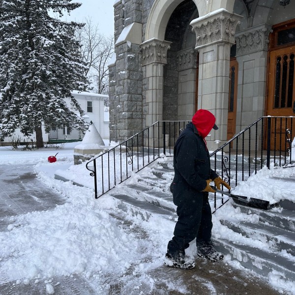 A man shovels snow outside a church