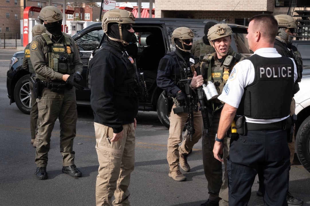 Border Patrol chief Greg Bovino speaks with a Chicago Police officer 