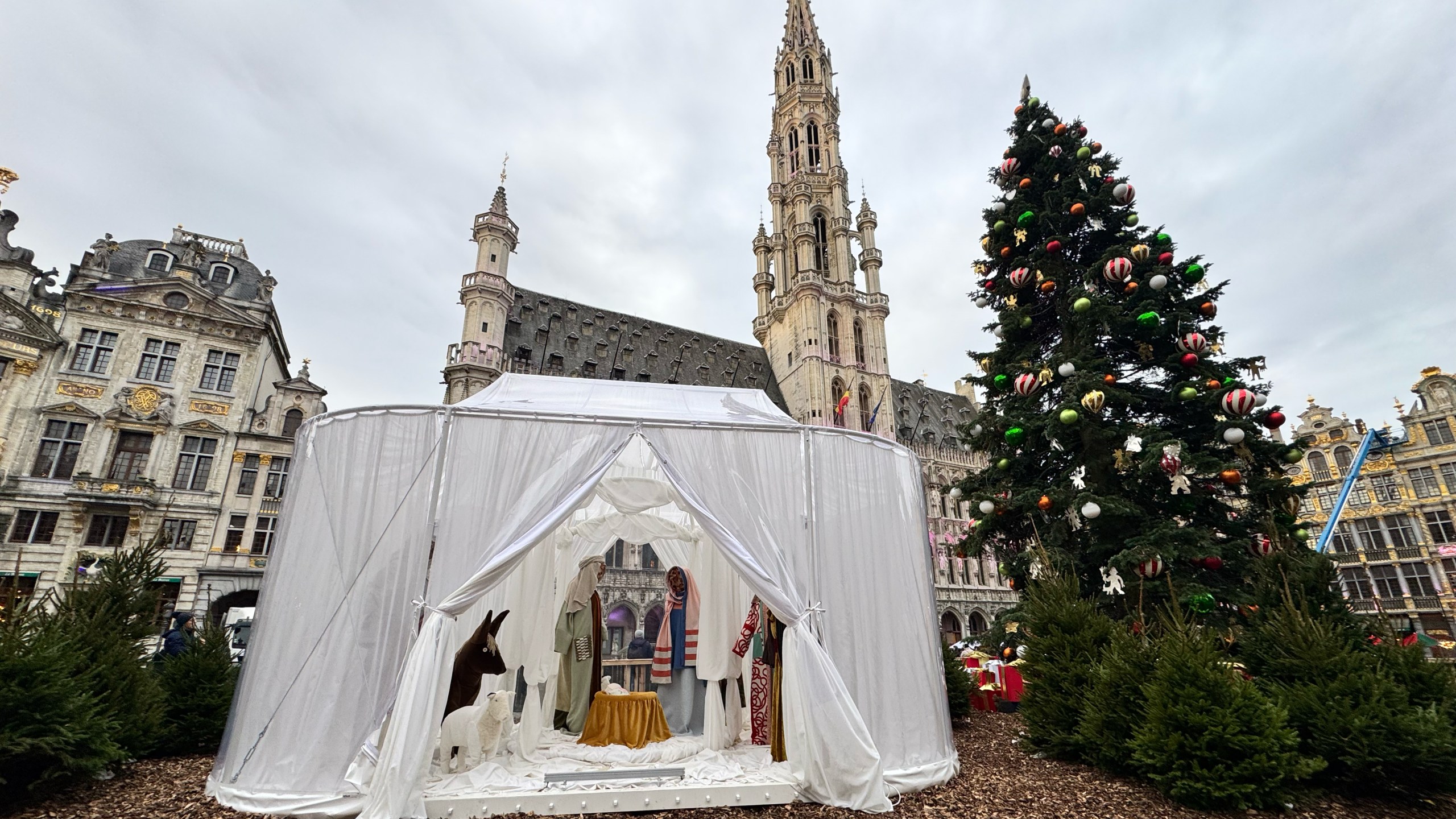 A Nativity scene containing characters with cloth faces, by Belgian artist Victoria-Maria Geyer, is displayed in a white tent in Brussels, Monday, Dec. 1, 2025. (AP Photo/Sylvain Plazy)
