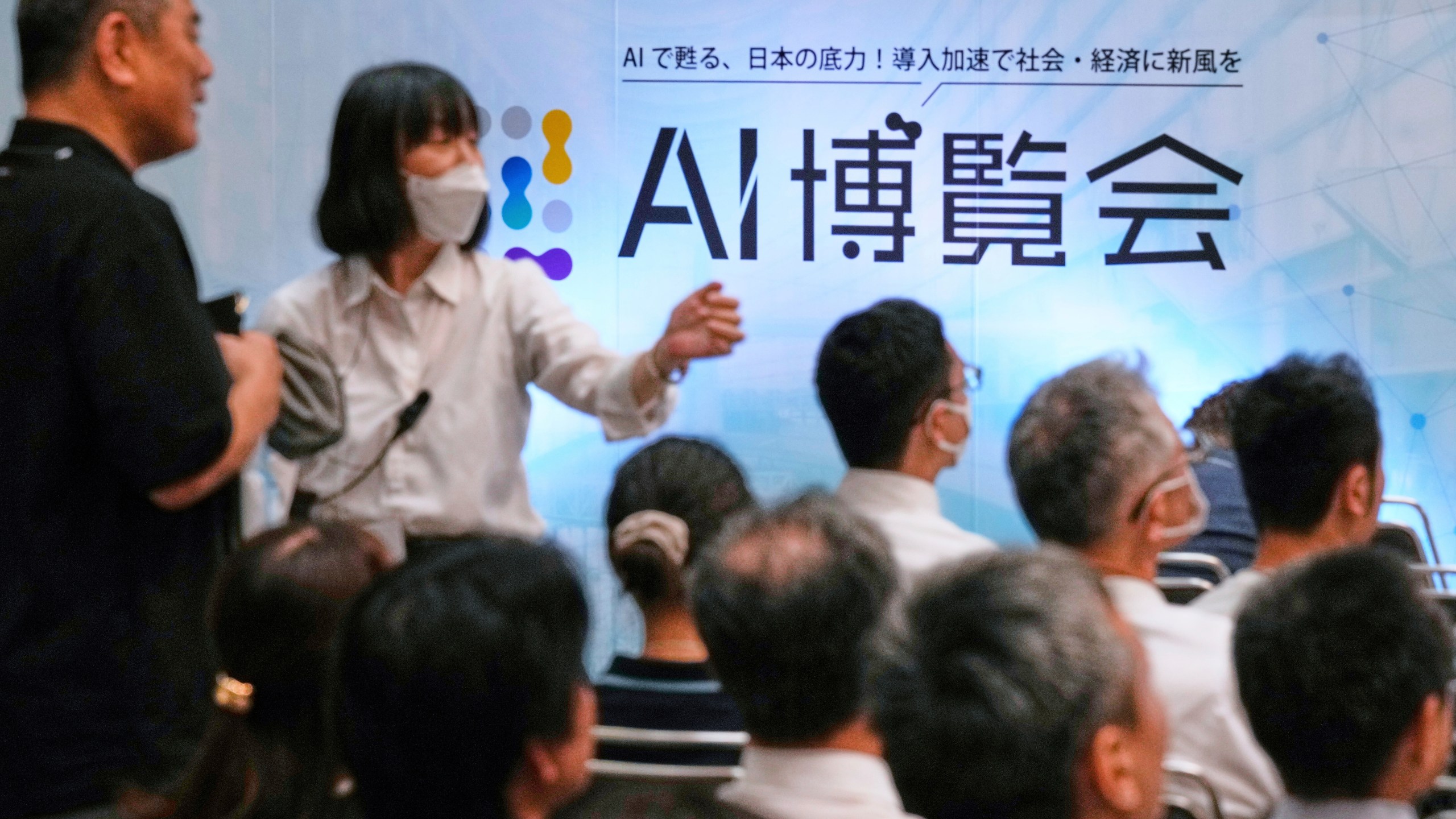 FILE - An usher directs an attendee to a seat for a seminar at a convention titled AI Expo in Tokyo, on Aug. 27, 2025. (AP Photo/Hiro Komae, File)