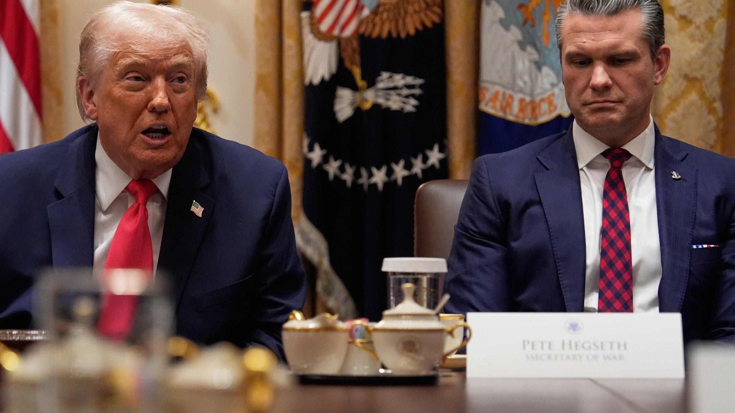 President Donald Trump speaks during a Cabinet meeting at the White House, Tuesday, Dec. 2, 2025, in Washington, as Secretary of Defense Pete Hegseth looks on. (AP Photo/Julia Demaree Nikhinson)