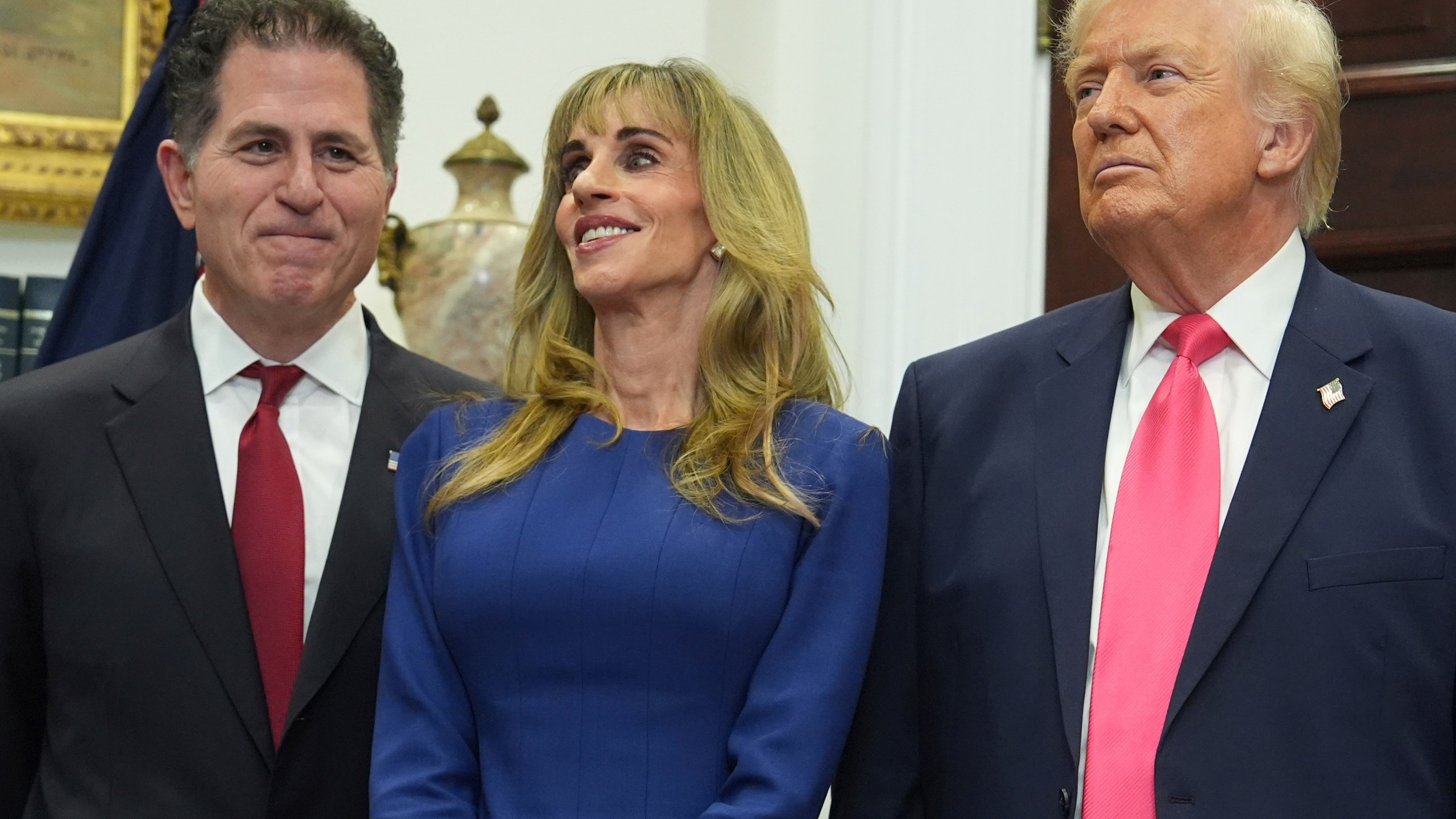 Michael Dell, left, his wife Susan and President Donald Trump listen during an event on "Trump Accounts" for kids in the Roosevelt Room of the White House, Tuesday, Dec. 2, 2025, in Washington. (AP Photo/Evan Vucci)