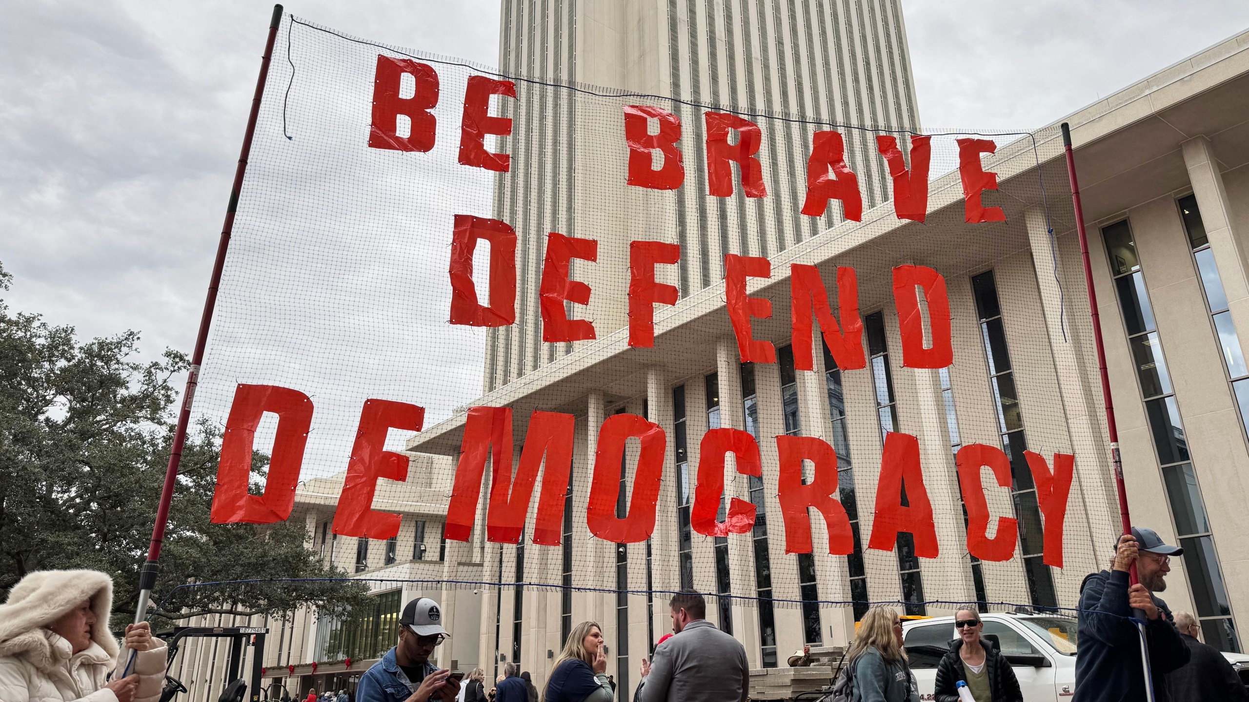 Protestors opposed to mid-decade redistricting hold a sign outside of the Florida Capitol in Tallahassee, Fla. on Dec. 4, 2025. (AP Photo/Kate Payne)
